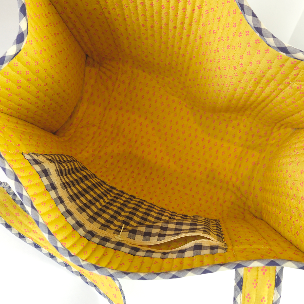 Close-up of a yellow fabric interior with checkered lining on a white background