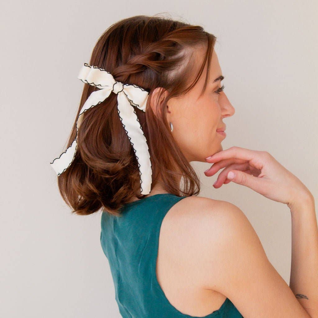 Every shop Andi accessory is specially designed to be comfortable, stylish, and practical, and our bows are no exception! This medium bow clip is absolutely a must. Made with a cream ribbon, featuring a black scalloped trim, it matches any hairstyle and outfit, seamlessly, and attached to an alligator clip, it's so easy to apply. 