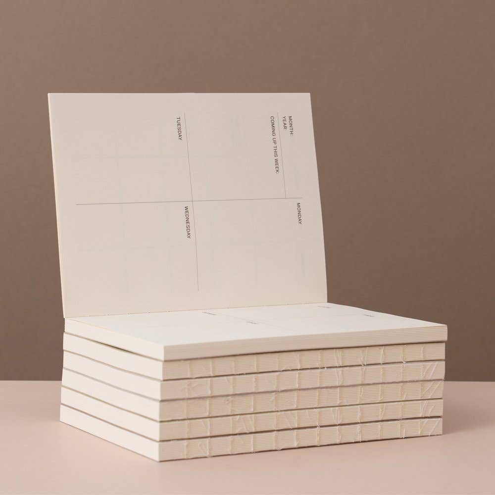 Stack of white books on a beige surface with a brown background