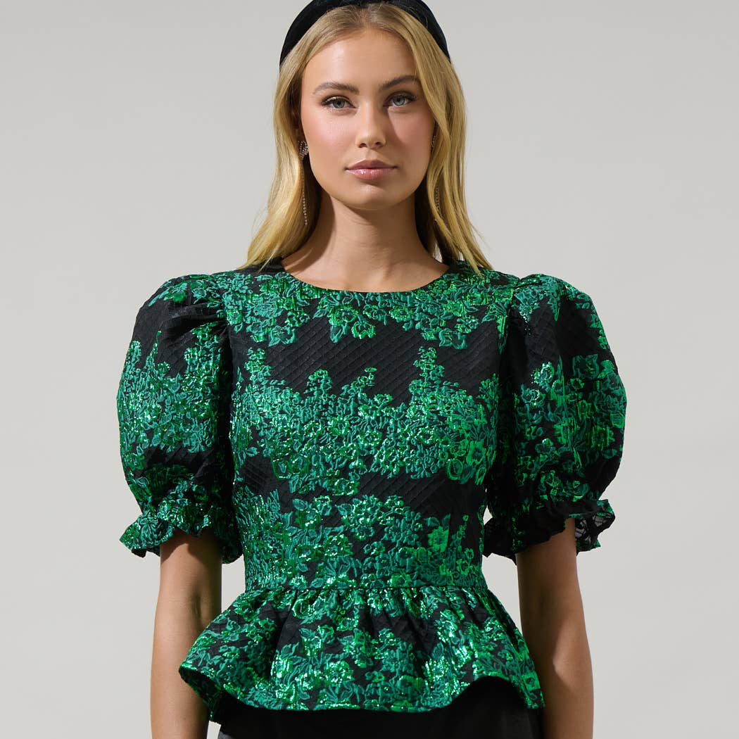 Whatever your plans may be, keep it cute when you wear the Elyna Jacquard Alena Cut Out Blouse. Short puff sleeves with elastic cuffs frame a round neckline that leads to a cute out heart shape in the back. It has a peplum touch at the end. Wear it with a skirt or pants to create a lovely look.
Details:
Puff sleeve
Heart cut out Peplum
Zipper
Color: Green/Black
Model is 5'9"" and wearing size XS
Measurements taken from size S - Chest: 17 1/2"" - Length: 22 1/4""