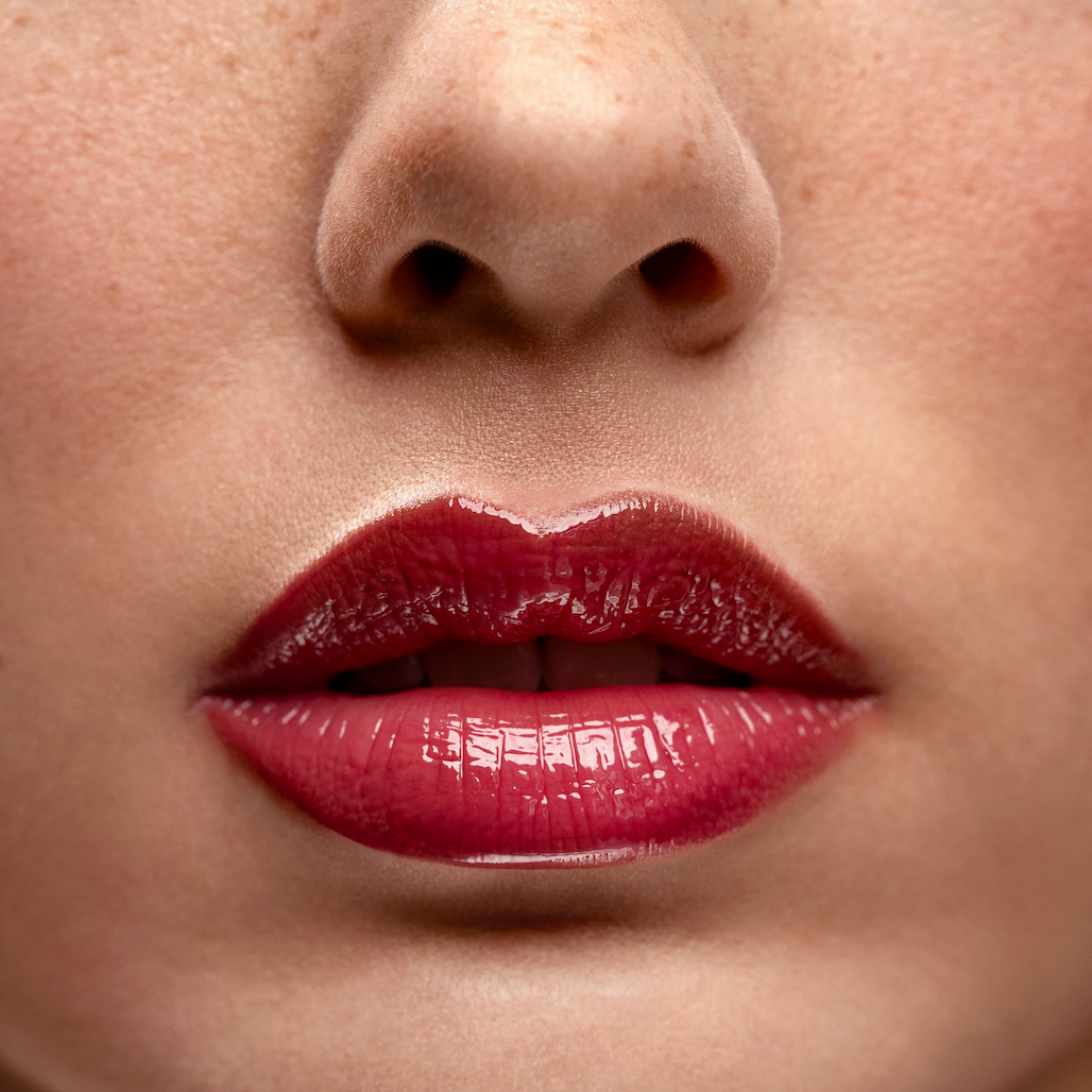 Close-up of a person's lips with red lipstick on a blurred background