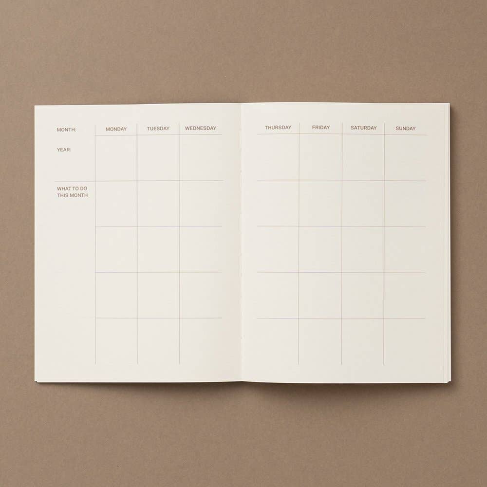 Open planner with grid layout on a brown background