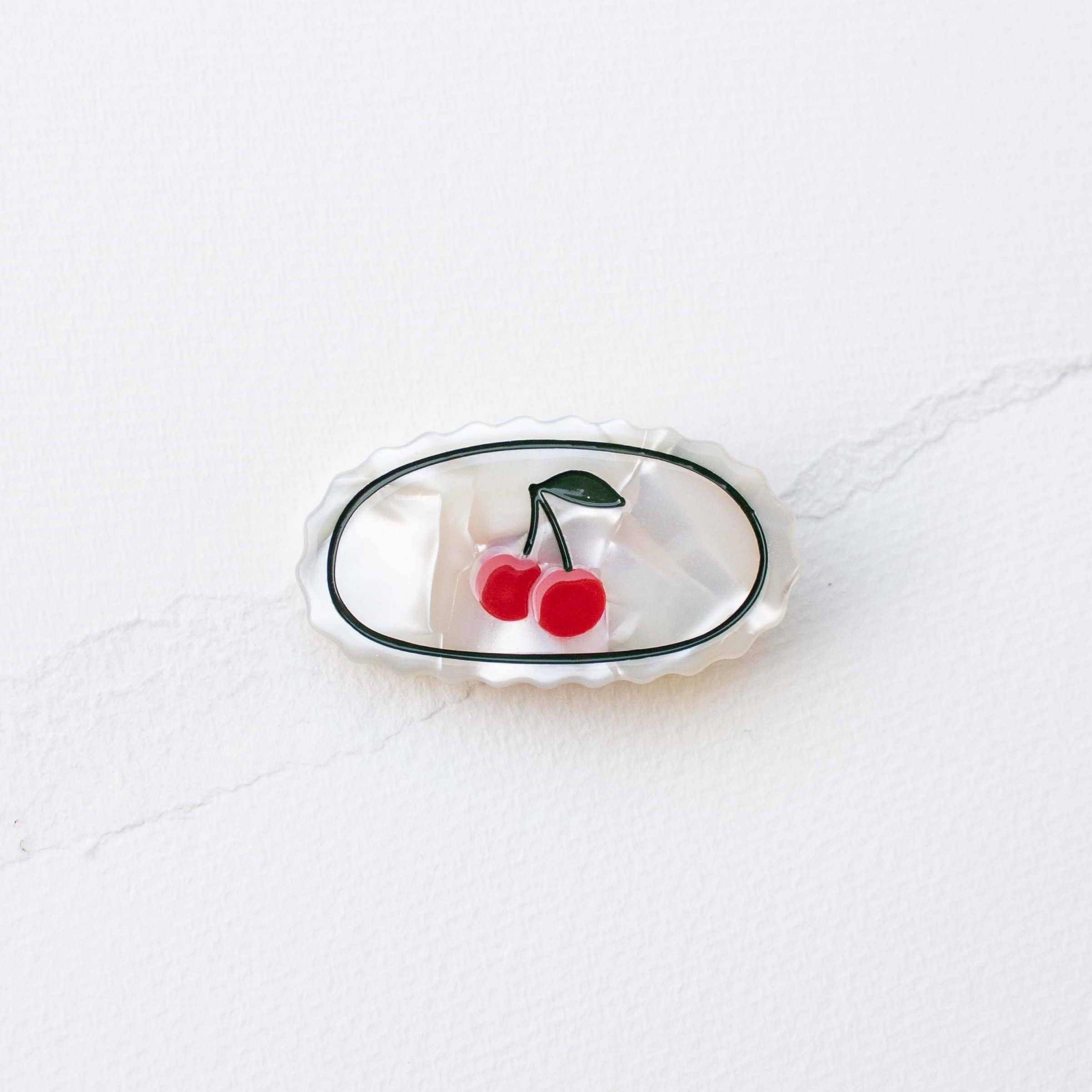 Hold your hair in place with effortless style using this cream and cherry claw clip. Crafted from eco-conscious acetate, this oval-shaped accessory combines sustainability with everyday functionality. Perfect for securing updos, half-styles, or keeping hair off your face, it's a versatile addition to any routine. The soft, neutral tones complement any look while the durable design keeps your strands secure throughout the day.