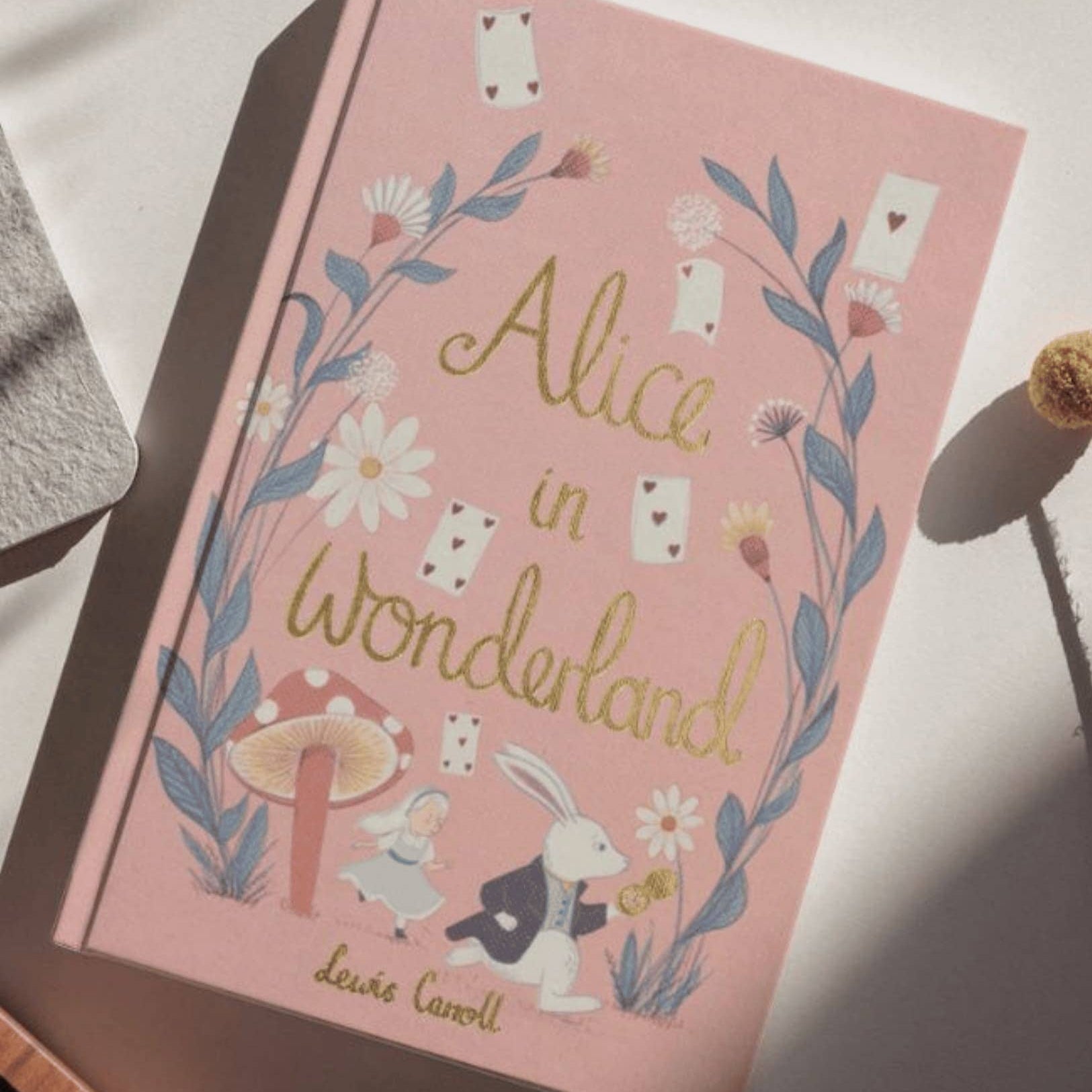 Book titled 'Alice in Wonderland' with decorative cover on a light surface