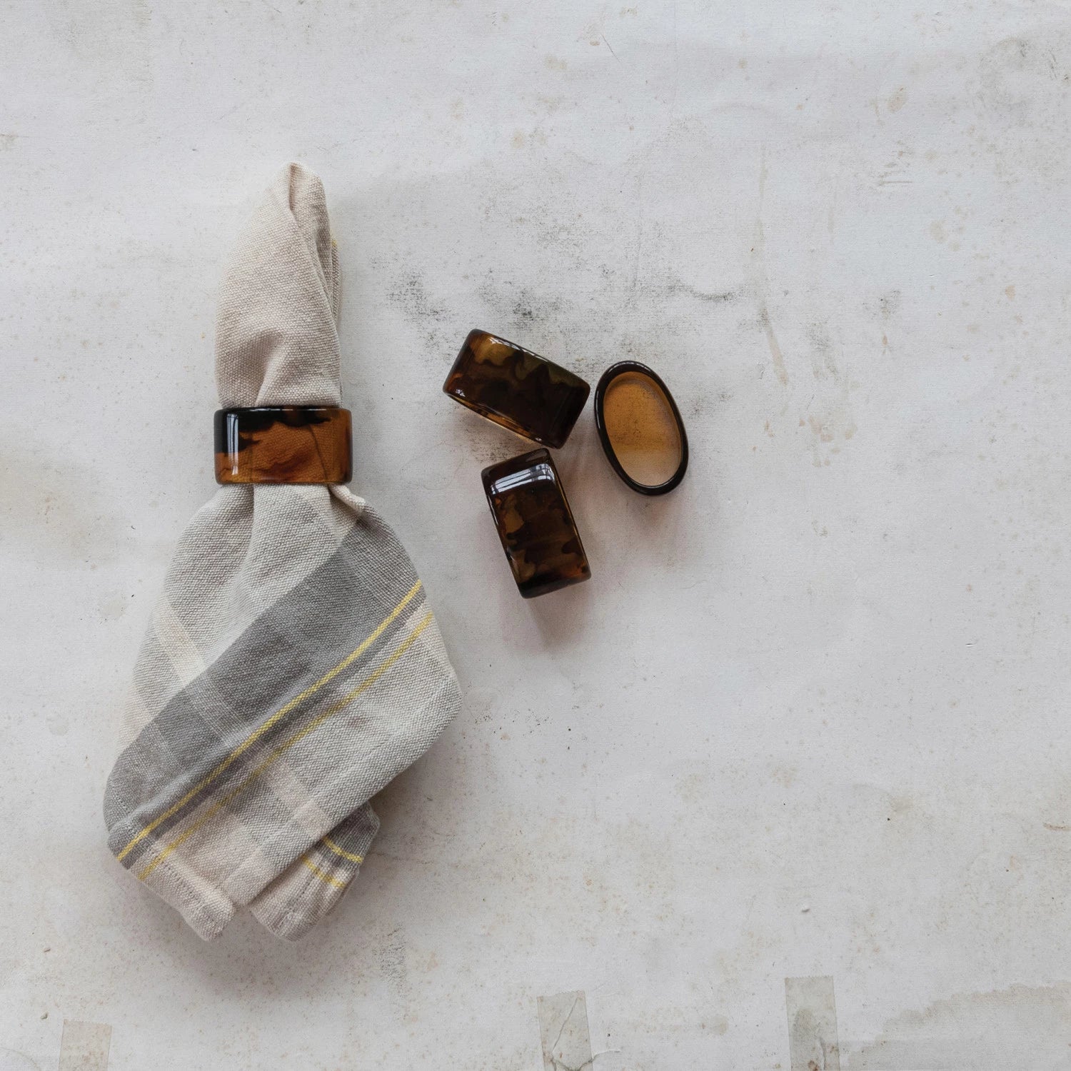 Add a touch of whimsy to your table with this set of four napkin rings, each featuring a unique tortoise shell finish. No two are alike, making every place setting a fun surprise. Perfect for brightening up dinners and sparking conversation! 2"L x 1-1/4"H