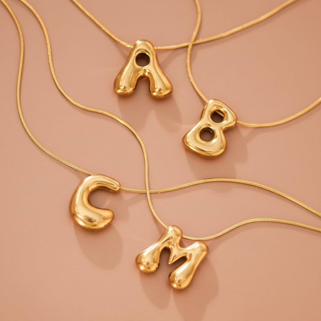 Elevate your everyday style with this 18K gold dipped stainless steel initial necklace. Featuring a bubble letter design, this versatile piece measures approximately 15.75" with a 2" extender for a customizable fit. Hypoallergenic and waterproof, it resists tarnish to maintain its lustrous finish. Available in initials A through Z with select options. To preserve the gold plating's brilliance, avoid prolonged contact with lotions, perfumes, and cleaning products.