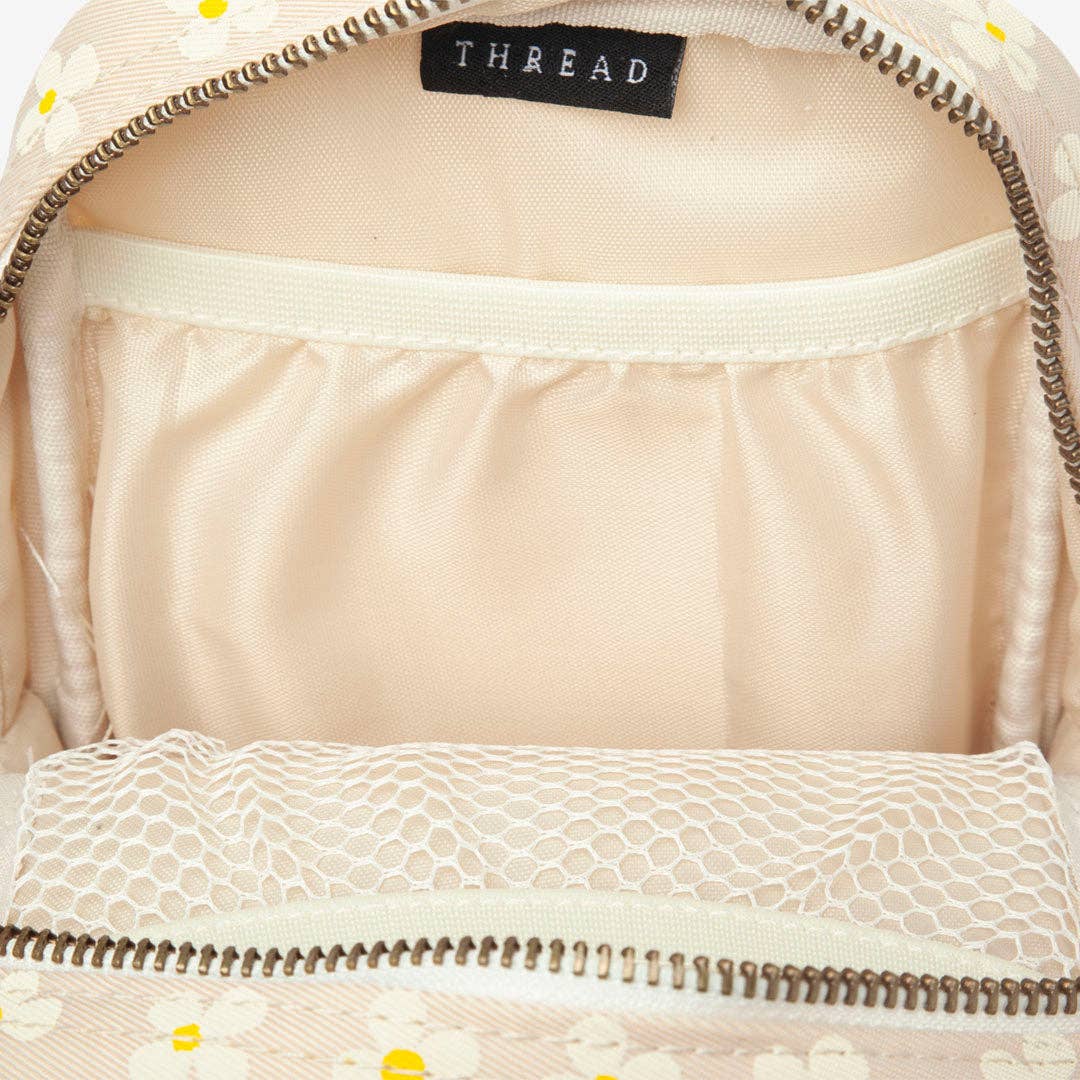 Close-up of a beige bag with lace detailing and 'THREAD' label.