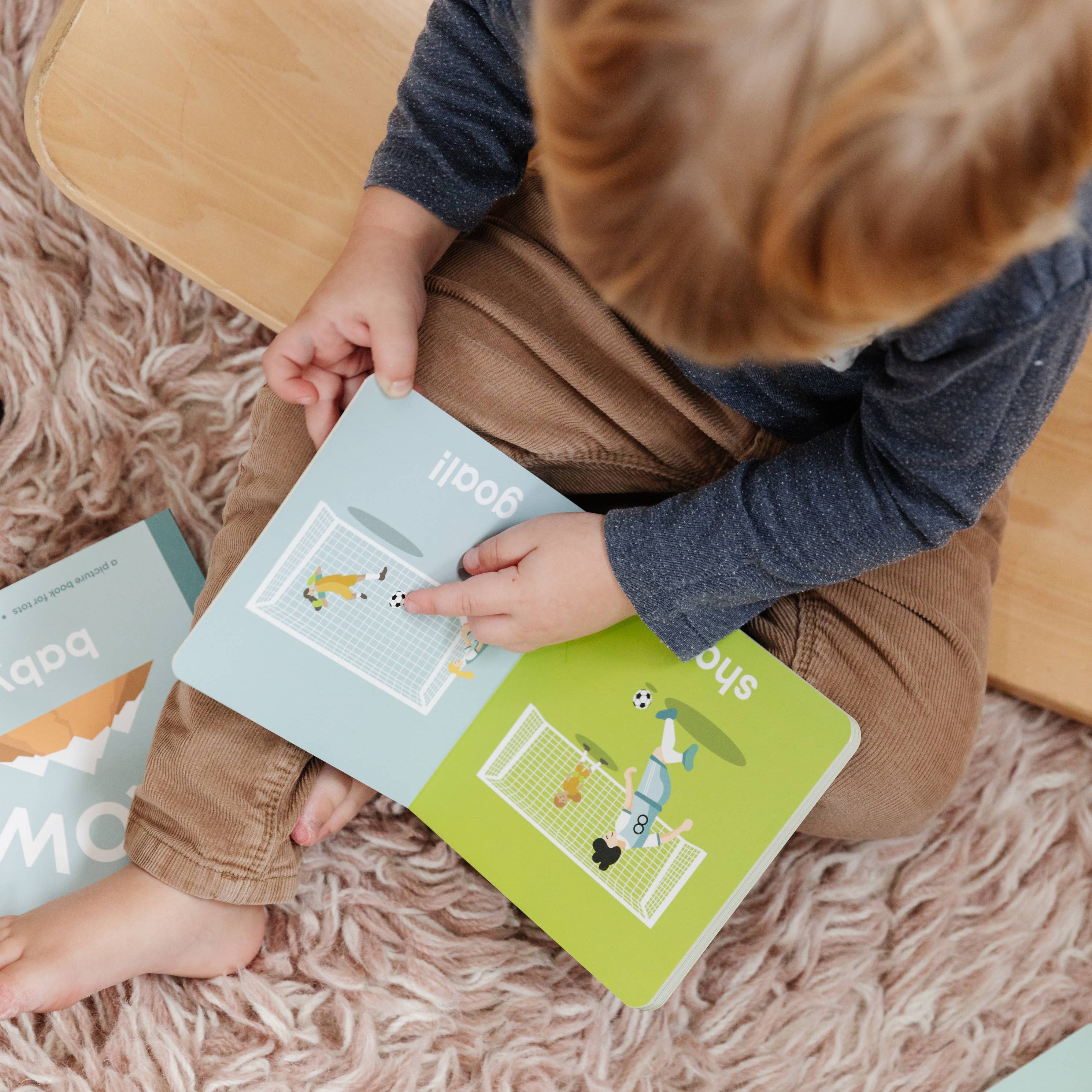 Child reading books on a fluffy carpet