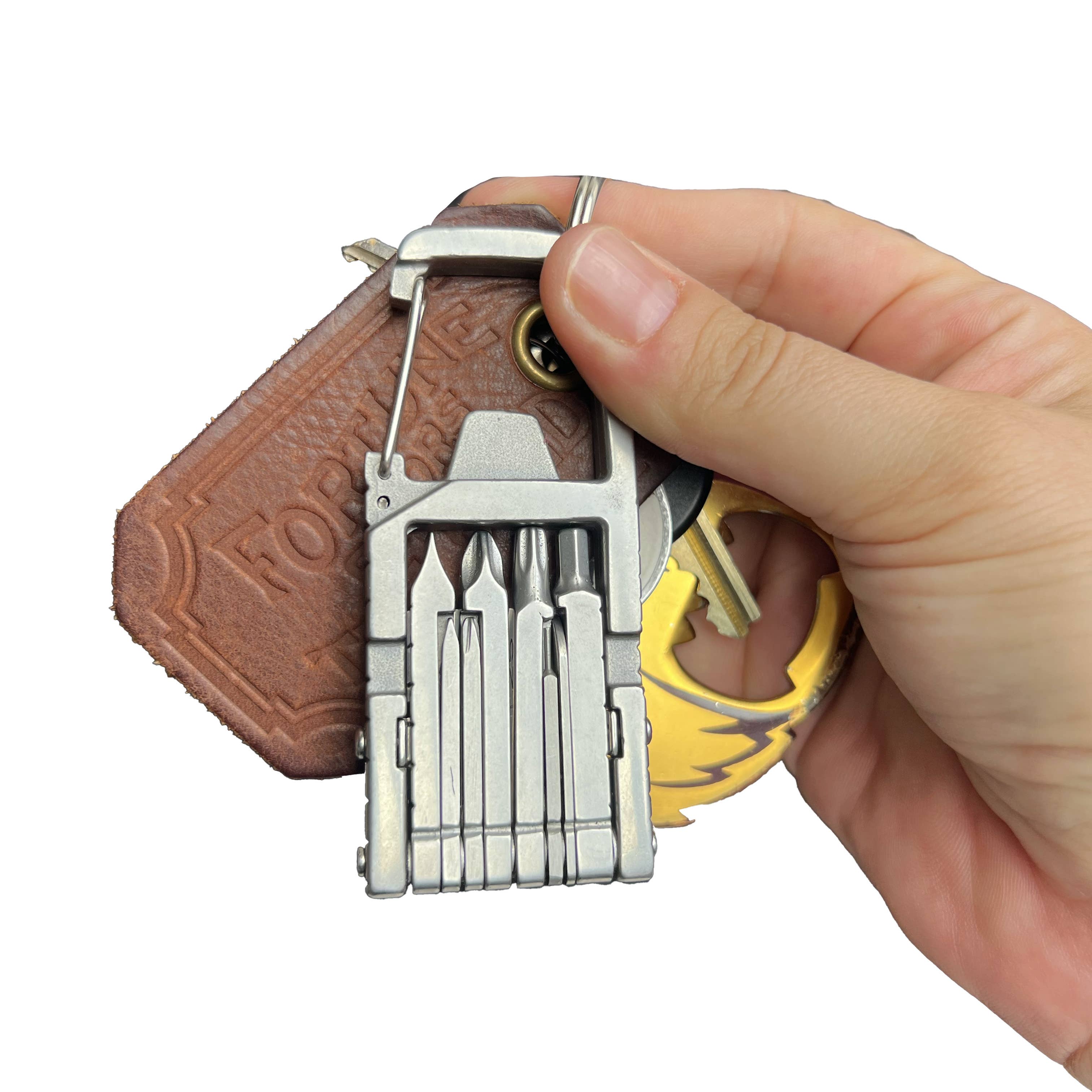Multitool keychain with leather pouch held by a hand on a white background