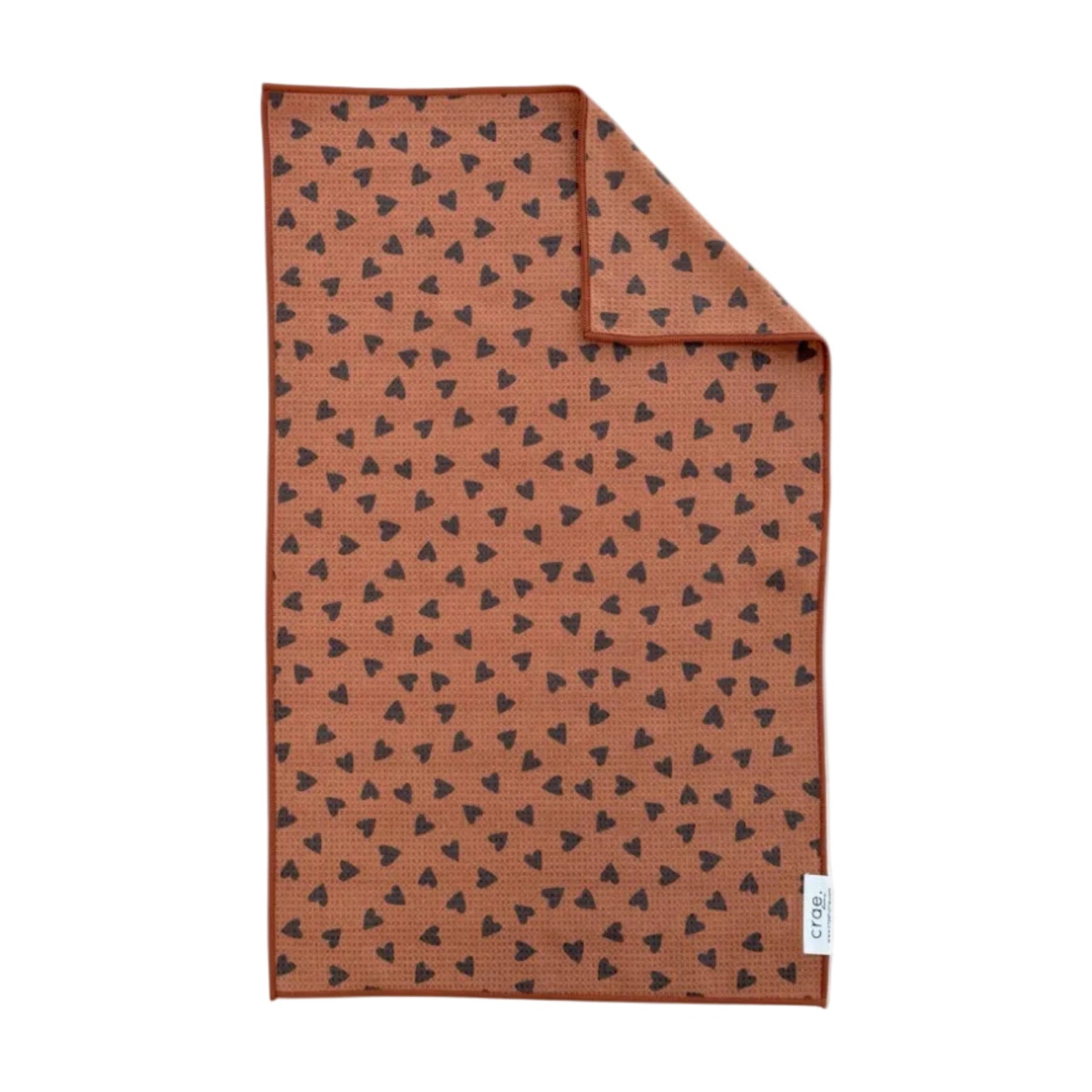 Brown towel with black heart pattern on a white background