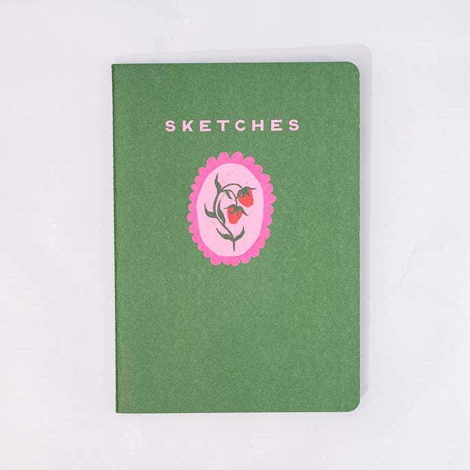 Green notebook with a pink floral design and 'SKETCHES' text on a white background