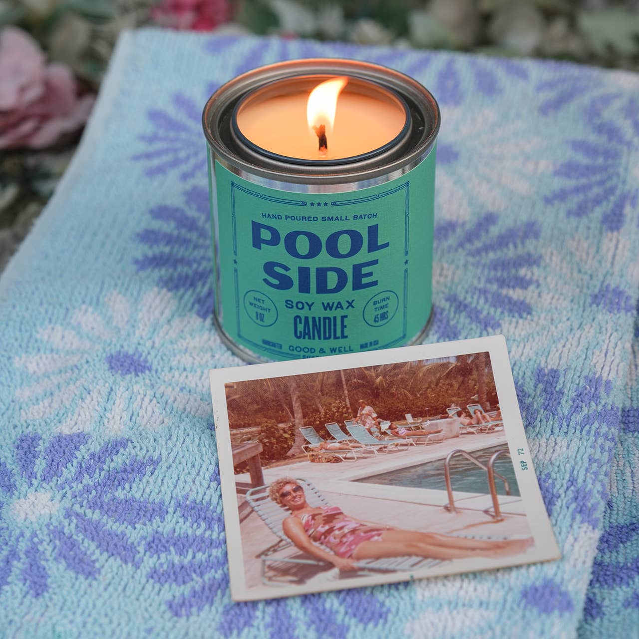 Candle in a 'Pool Side' tin with a vintage-style photo of a woman by a pool on a textured fabric background.