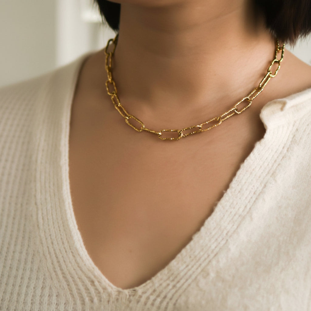 Elevate your everyday style with this 18K gold dipped stainless steel chain necklace, featuring a textured large paperclip design. Crafted from hypoallergenic stainless steel, it's waterproof and tarnish-resistant for lasting wear. The luxe gold plating maintains its brilliant shine when kept away from lotions, perfumes, and harsh chemicals. Perfect for layering or wearing solo, this versatile piece transitions seamlessly from day to night.