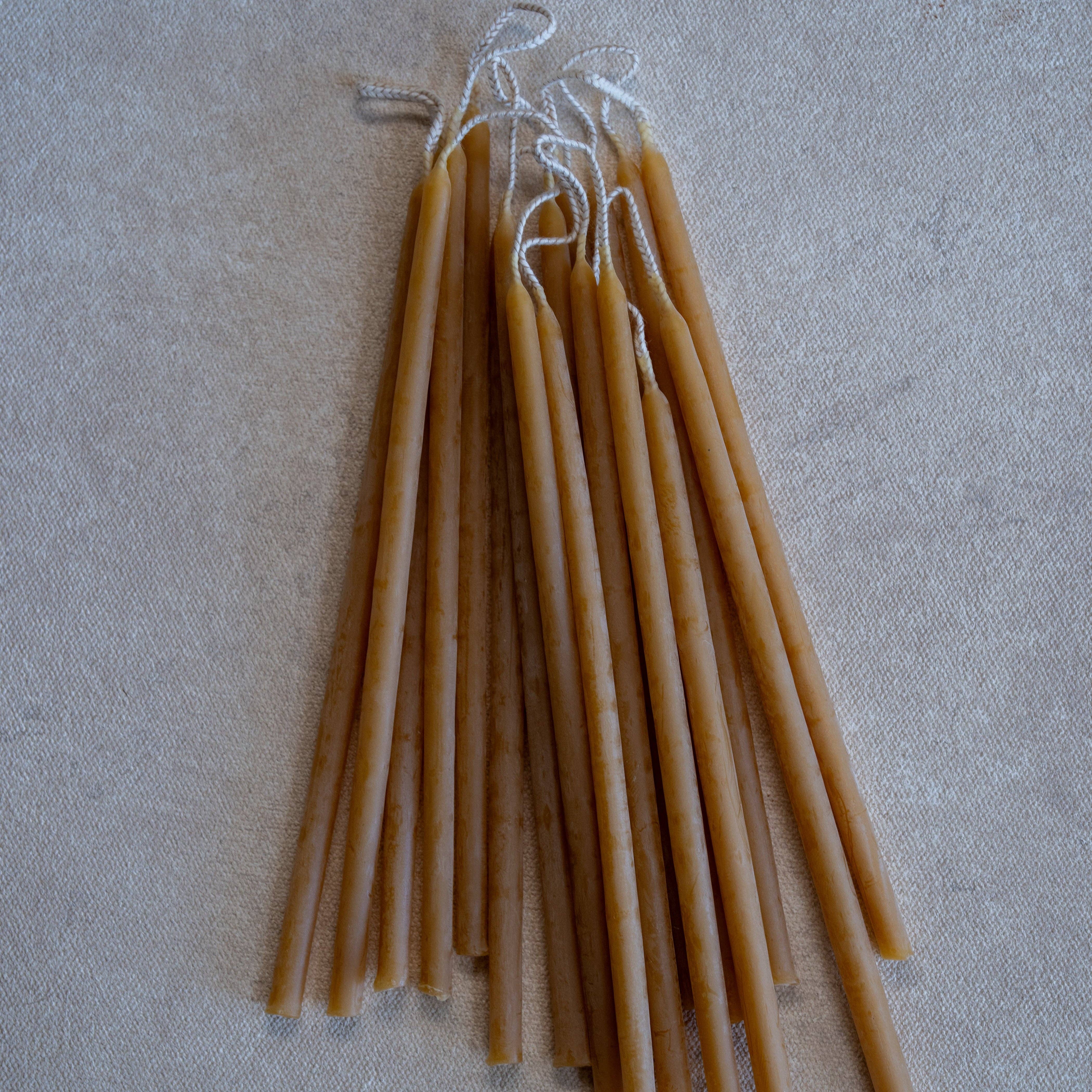 Set of beeswax candles on a textured beige surface, ohre color