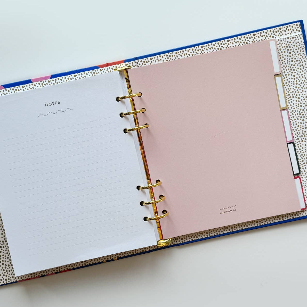 Open planner with pink and white pages on a light blue background