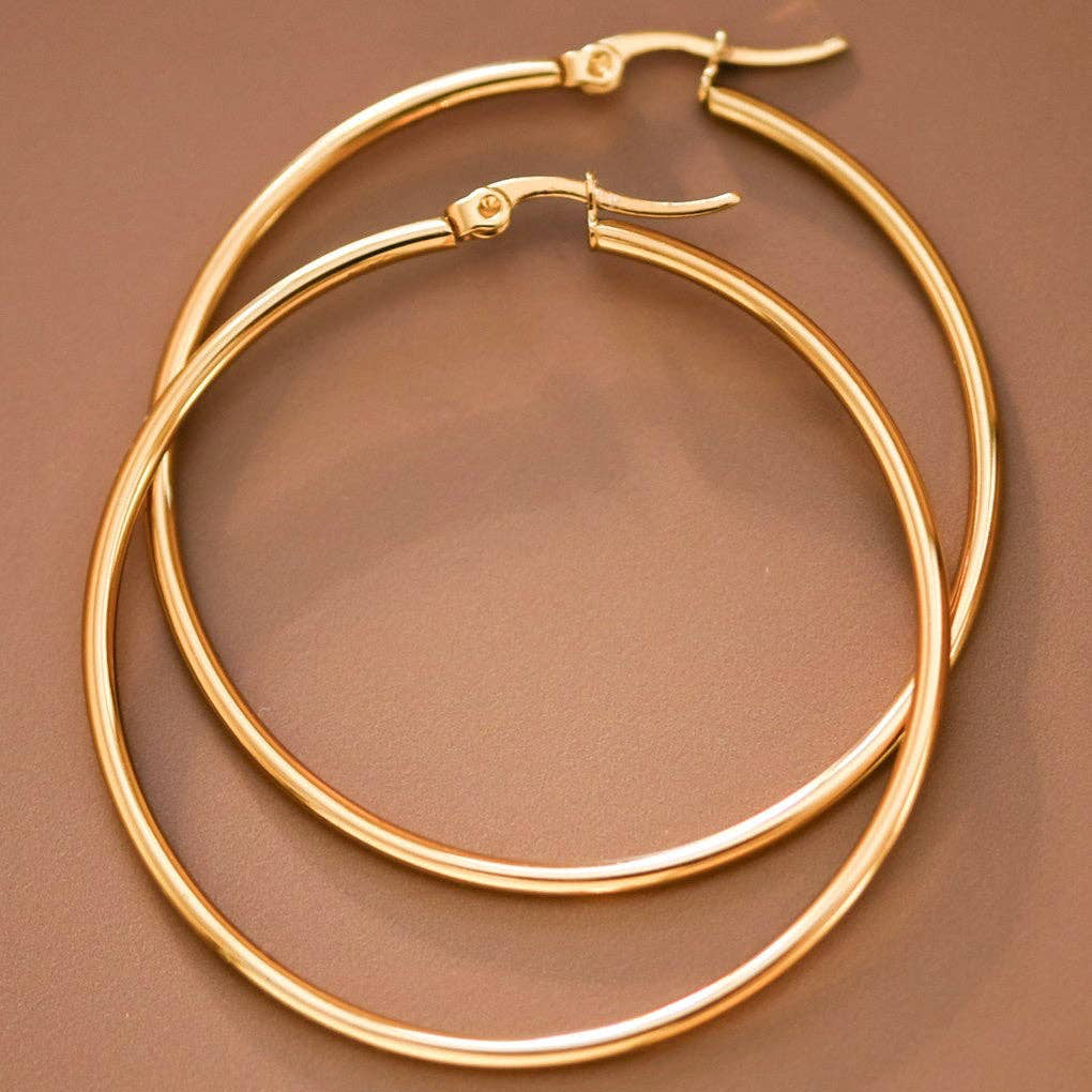Elevate your jewelry collection with these stunning 18K gold plated hoop earrings, measuring approximately 2 inches in length. Crafted from hypoallergenic stainless steel, they're perfect for sensitive skin and designed to withstand daily wear with their waterproof and tarnish-resistant properties. To maintain their lustrous finish, avoid prolonged contact with lotions, perfumes, and cleaning products. A versatile accessory that combines durability with timeless elegance.