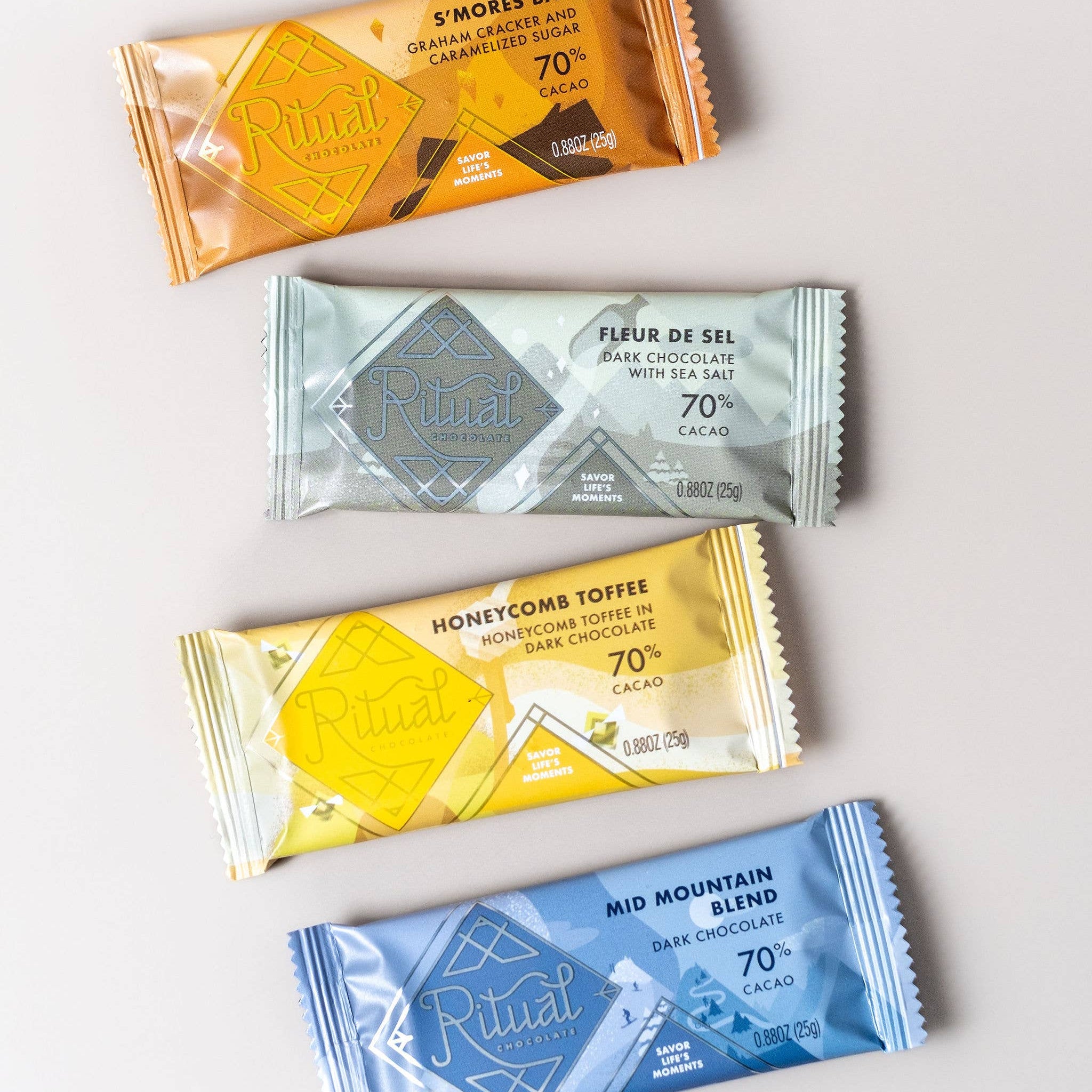 Four different chocolate bars with colorful packaging on a light gray background