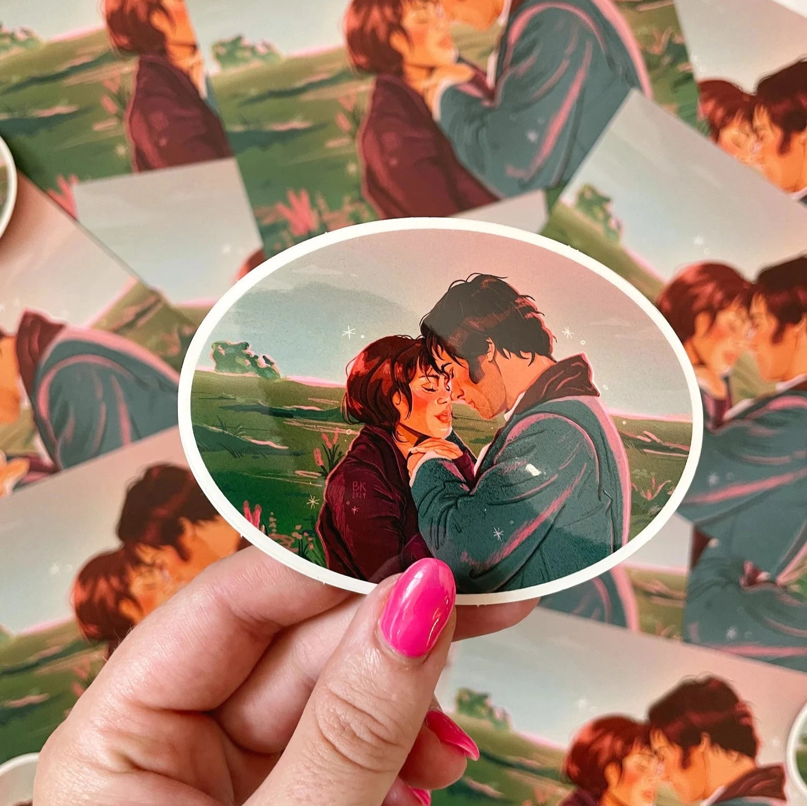 An oval sticker depicting an illustration of Mr. Darcy and Elizabeth holding hands with their faces close and their eyes closed.