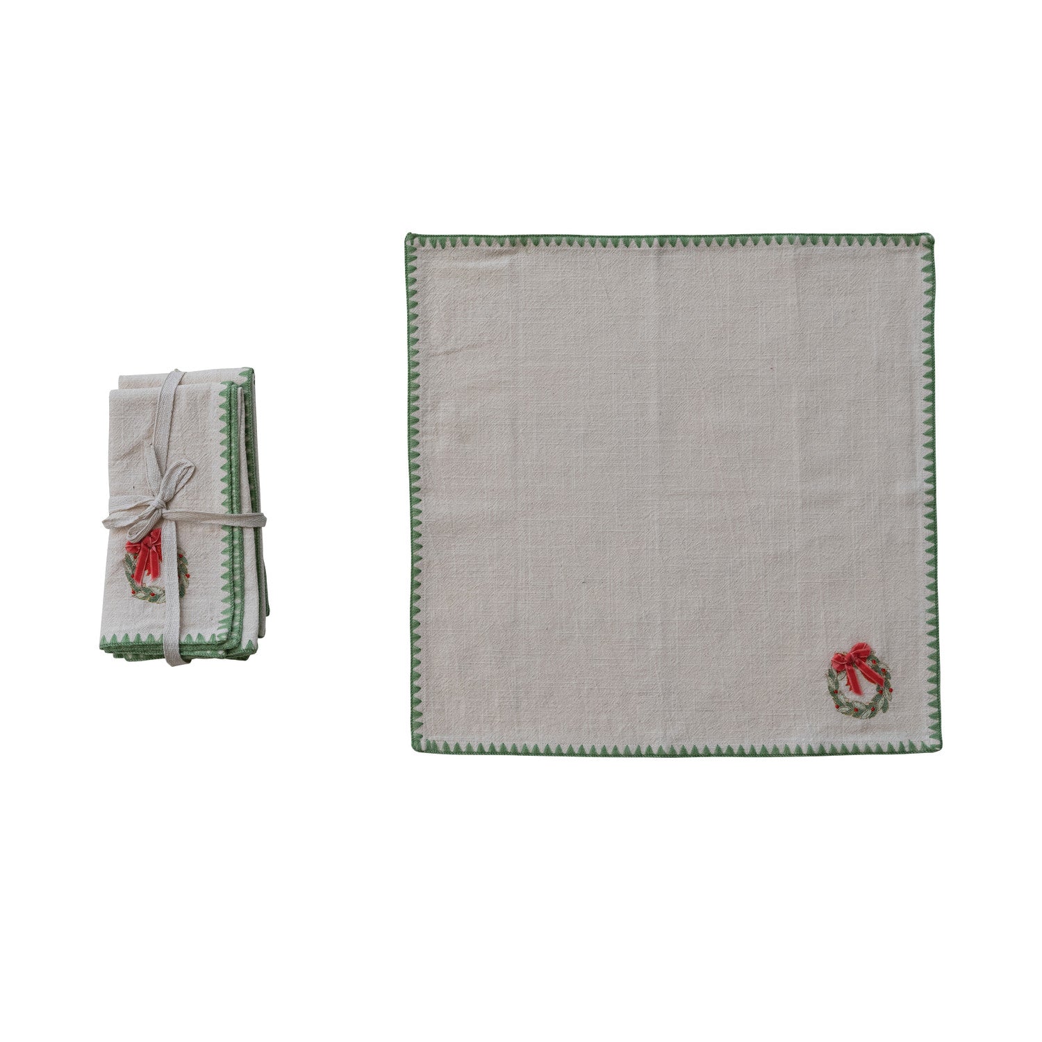 Set of folded napkins with embroidered wreath designs on a white background