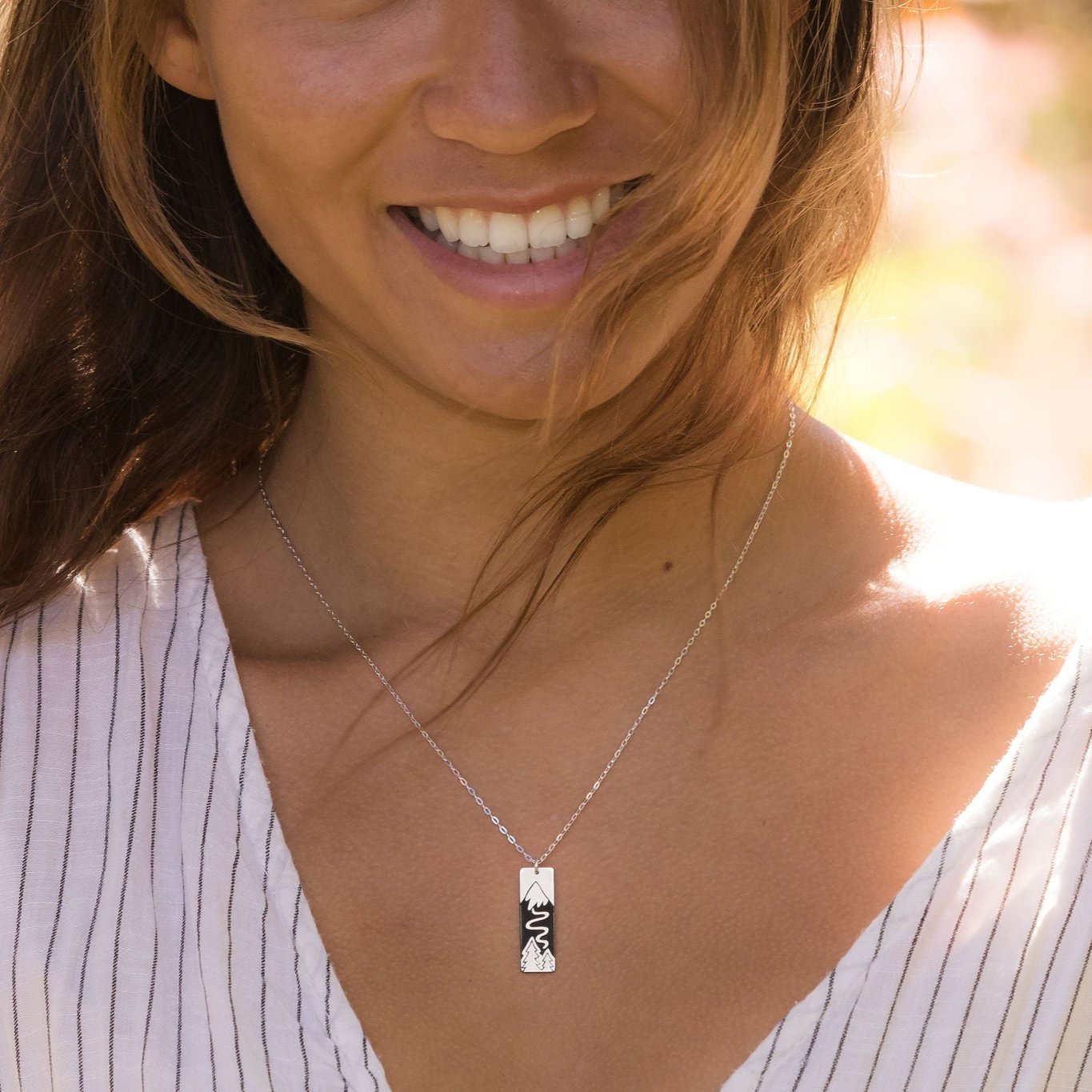 Solid Sterling Silver pendant. Polished finish on the front. Satin finish on the back. Solid Sterling Silver chain.