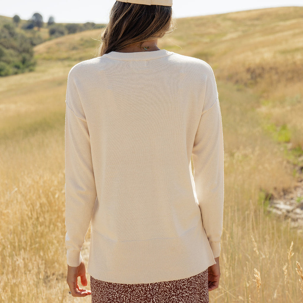 Featuring a playful high-low hemline and whimsical side slits, this sweater is as stylish as it is comfy! With ribbed details, a patch pocket, and a relaxed boxy fit, you'll feel warm and wonderful all day long. Ivory