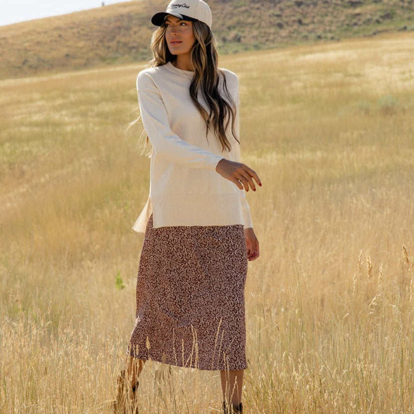 Featuring a playful high-low hemline and whimsical side slits, this sweater is as stylish as it is comfy! With ribbed details, a patch pocket, and a relaxed boxy fit, you'll feel warm and wonderful all day long. Ivory