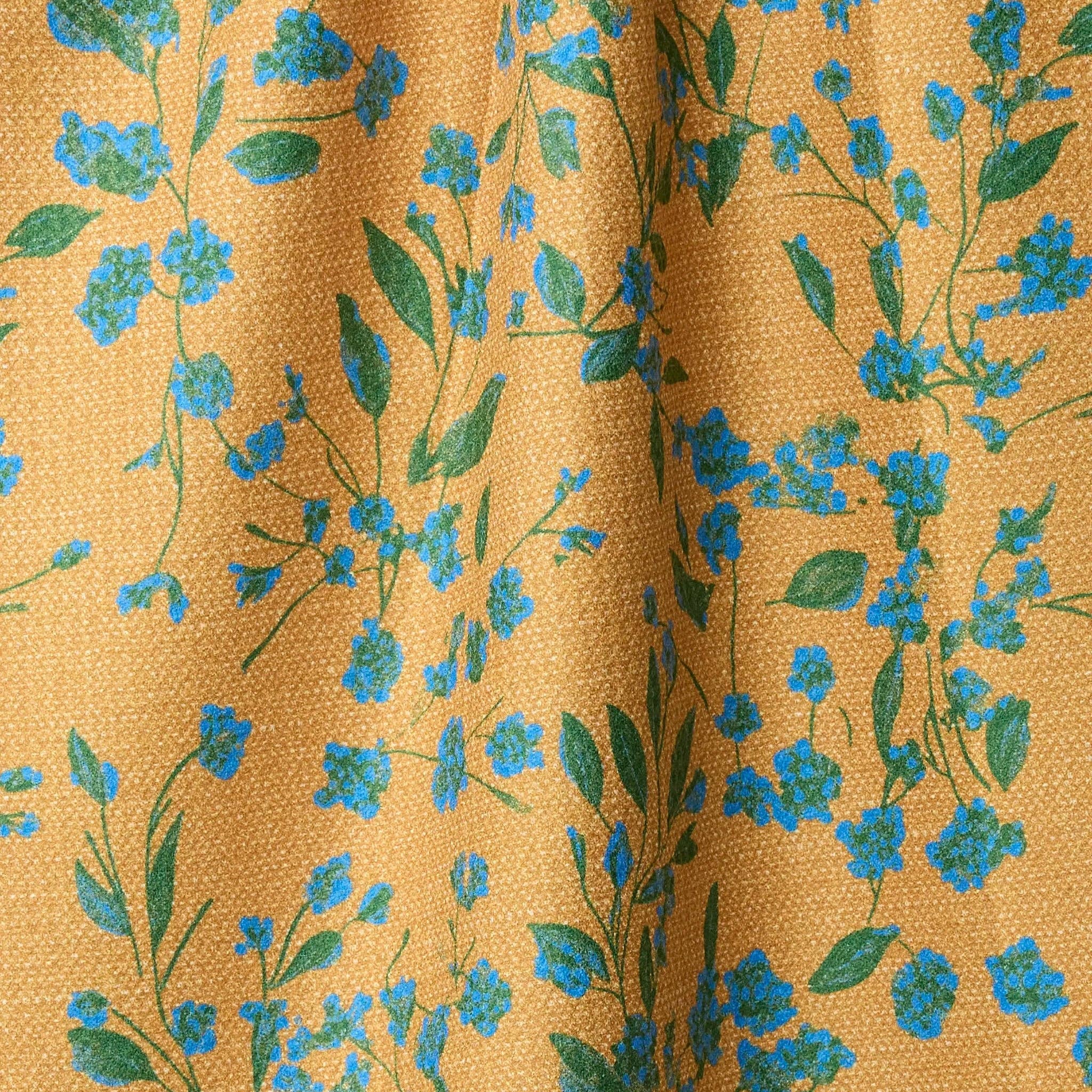 Close-up of ftea towel with blue floral pattern on a mustard yellow background