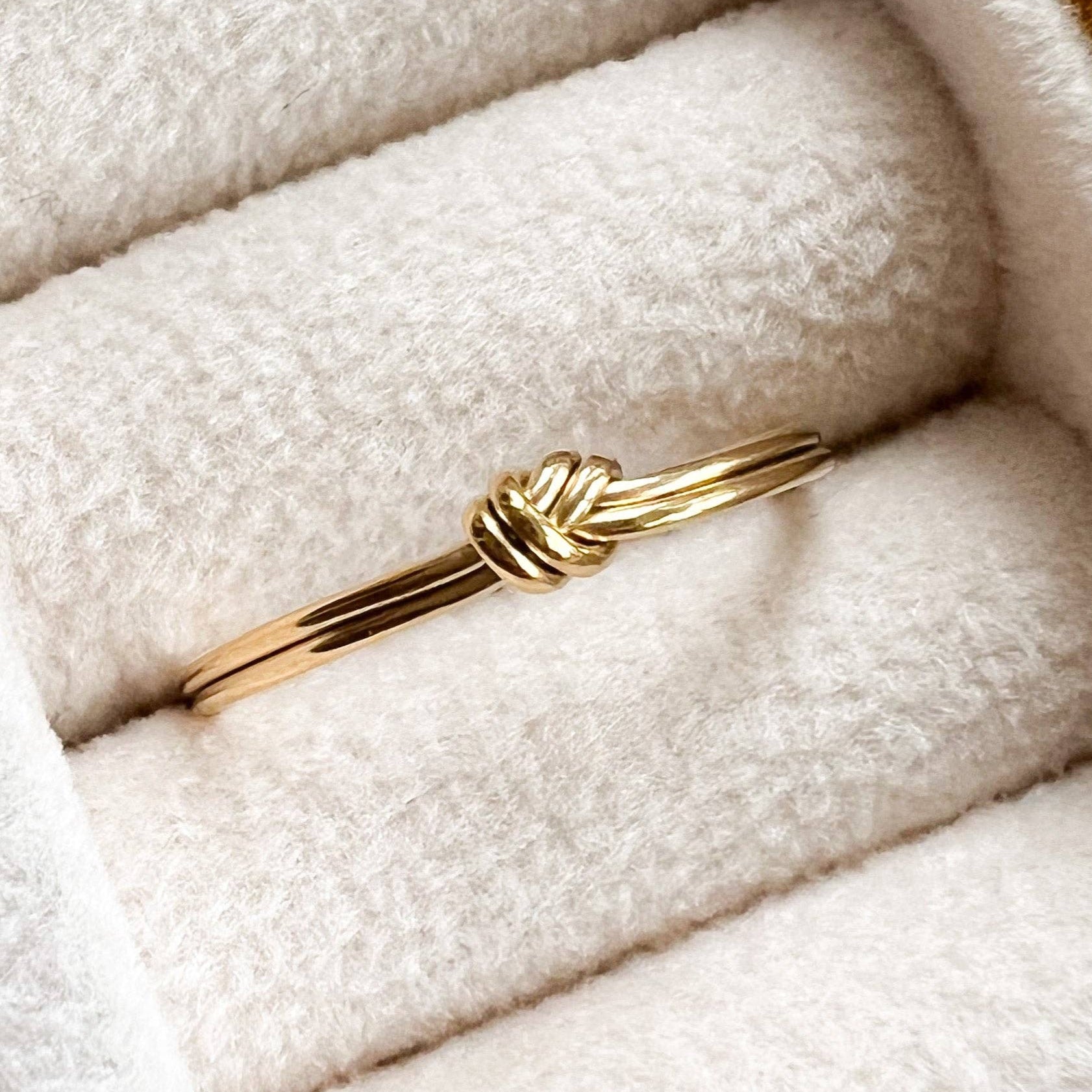 Gold ring in a jewelry box with soft white interior