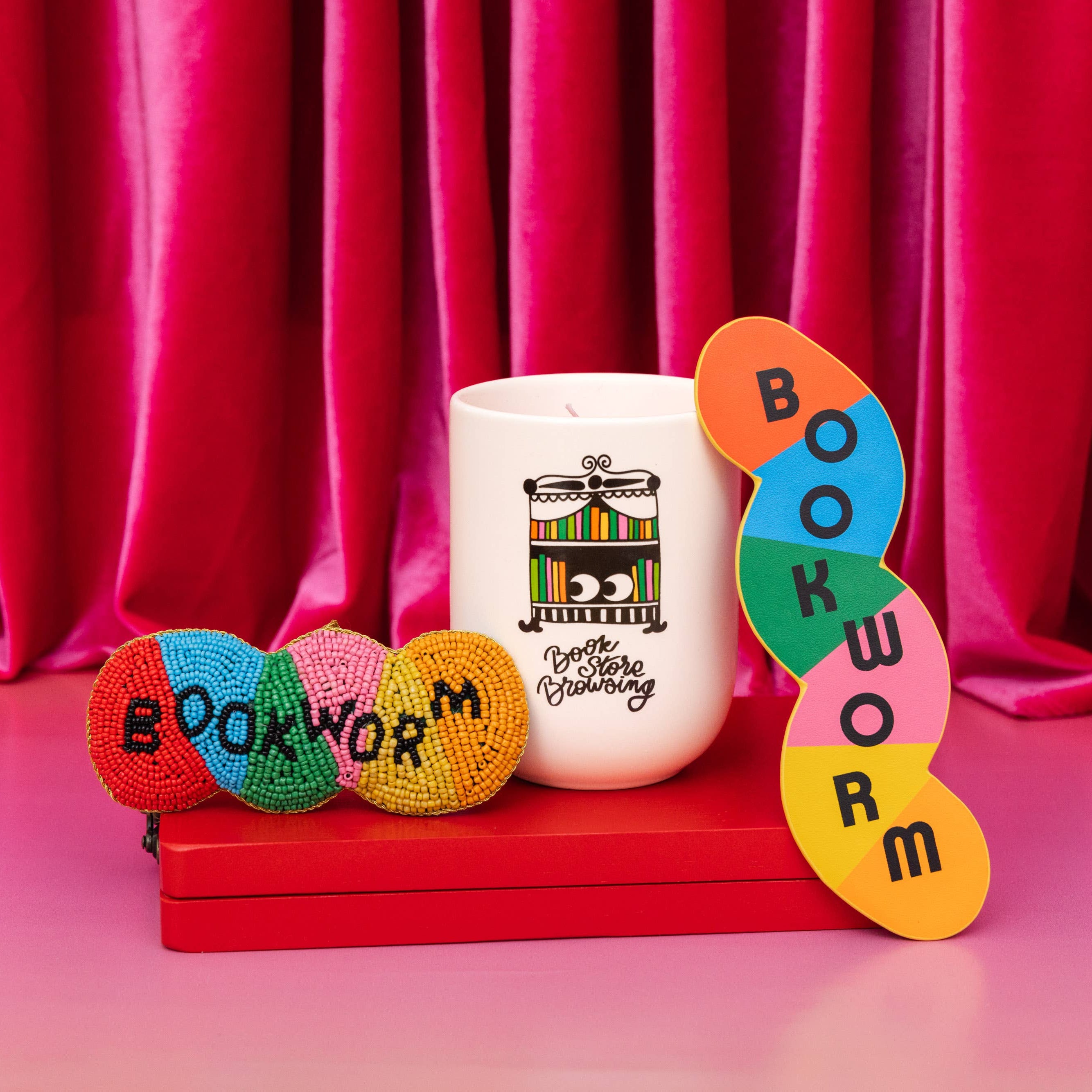Decorative items with 'bookworm' text against a red curtain background