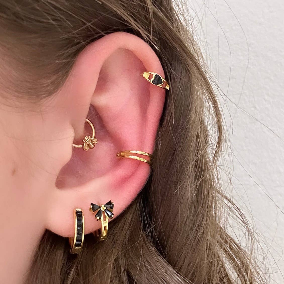 Add a touch of fun and classy to your every day by sporting these little bow huggie hoops! Bows aren't just functional and pretty knots for sealing gifts, they can represent strength, union, and beauty.

•&nbsp;925 sterling silver with gold plating

• Extra layer of tarnish resistance

• Black Cubic Zirconia stones

• Manufactured for our curated collection.