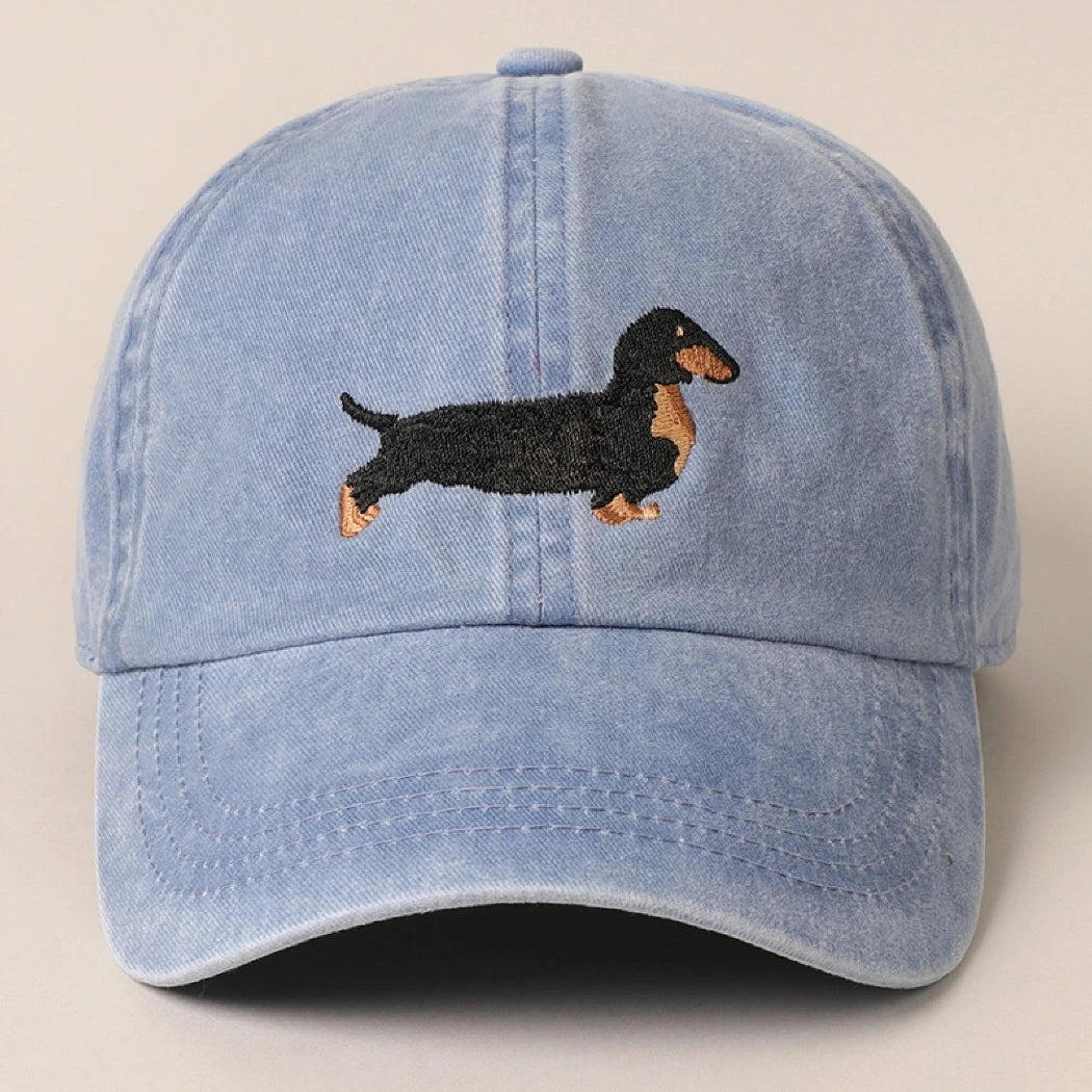 Get ready to walk the dog in style with our Dachshund Embroidered Baseball Cap! This washed denim blue hat features a playful embroidered Dachshund dog, perfect for any dog lover. Whether you're a baseball dad or just love a good ball cap, this unique and quirky accessory will add a touch of humor to any outfit.