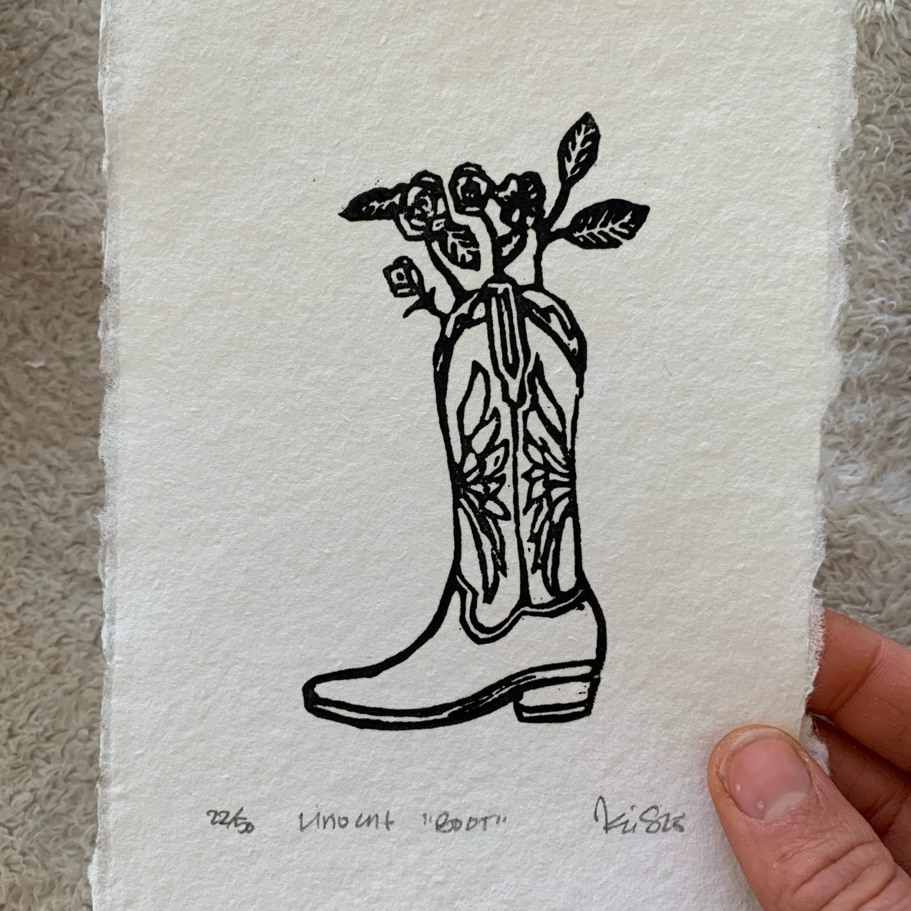 a relief linocut of a cowboy boot with roses coming out of the top
