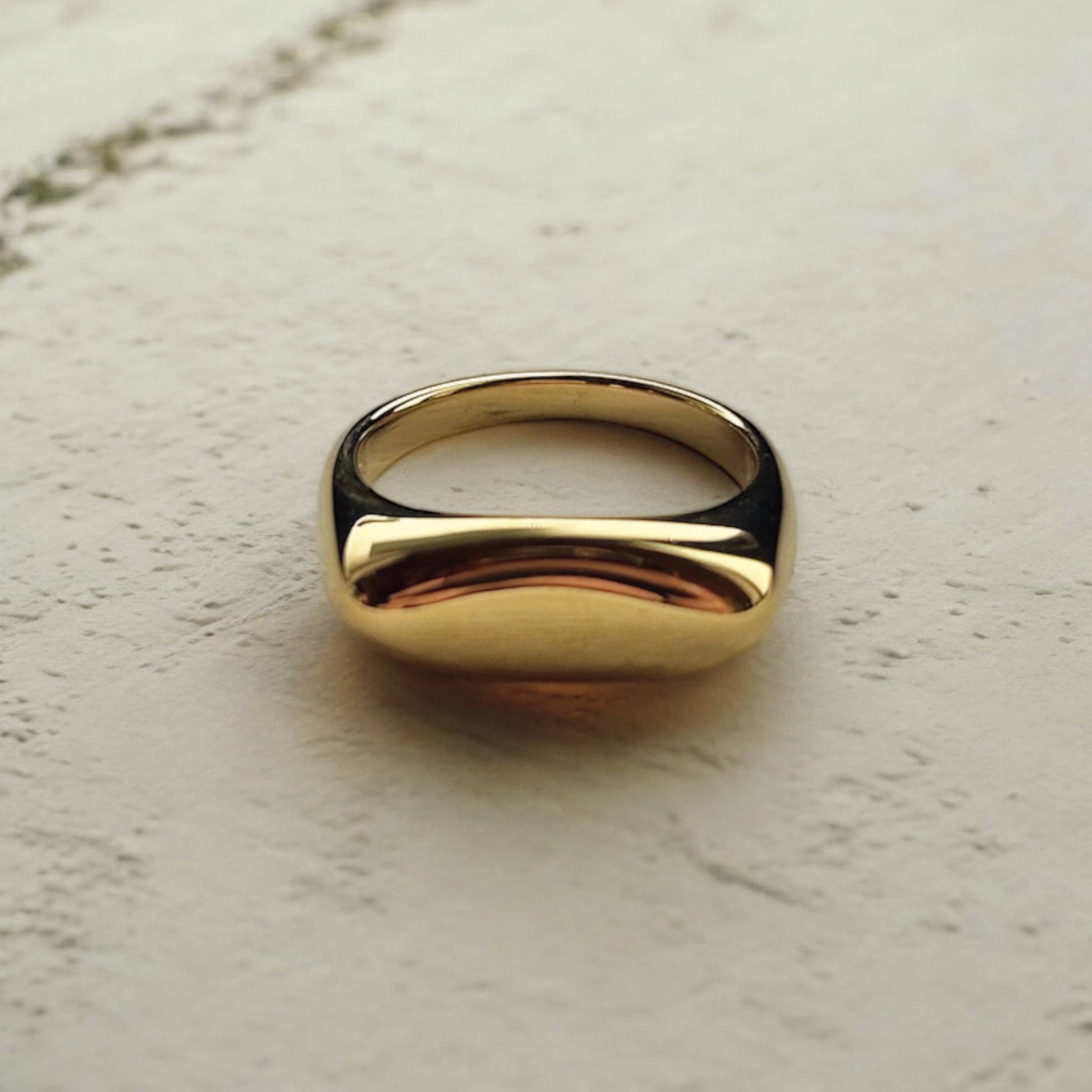 Gold ring on a textured beige surface