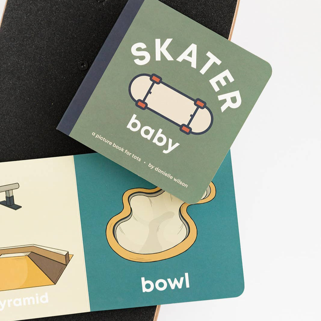 Children's book titled 'Skater Baby' on a skateboard with illustrations of skateboarding elements.