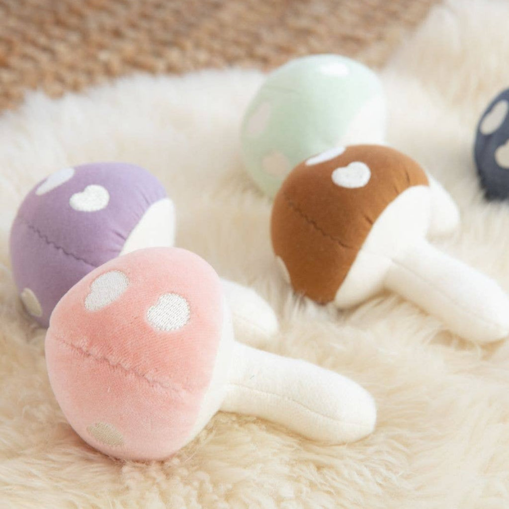 Let this Mushroom Rattle add a touch of whimsy to your baby's toy collection. Made of soft pink velour, it's perfect for tiny hands to shake and play with. It also makes a gentle rattling sound to stimulate sensory development. It's the perfect blend of cute and practical. Fungi never looked so fun!     * 100% GOTS certified organic cotton  * Filled with organic cotton and naturally hypoallergenic corn fiber  * Securely sewn plastic-free, BPA-free, phthalate-free rattle  * 5x4 inches