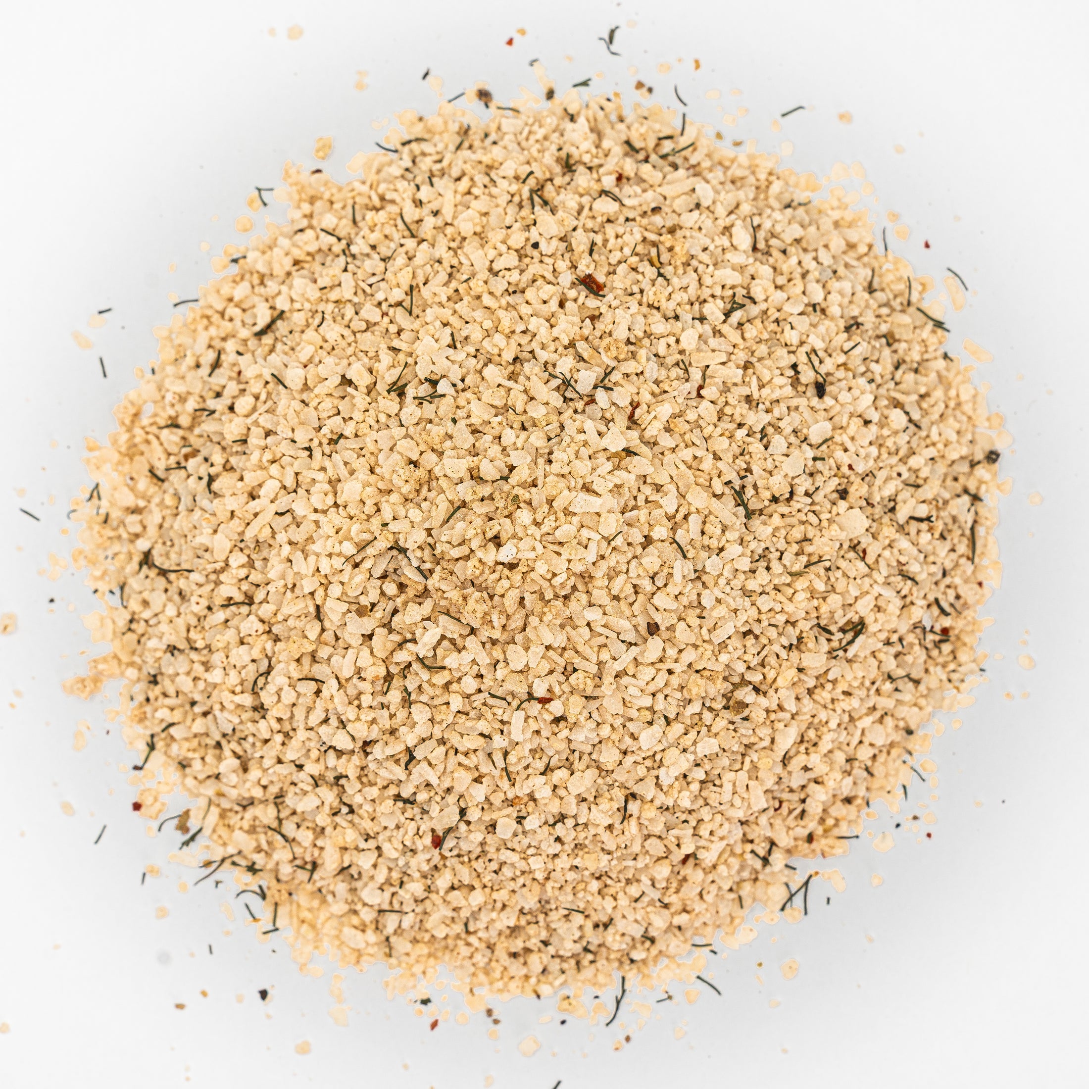 Mound of beige salt with flecks of herbs. 