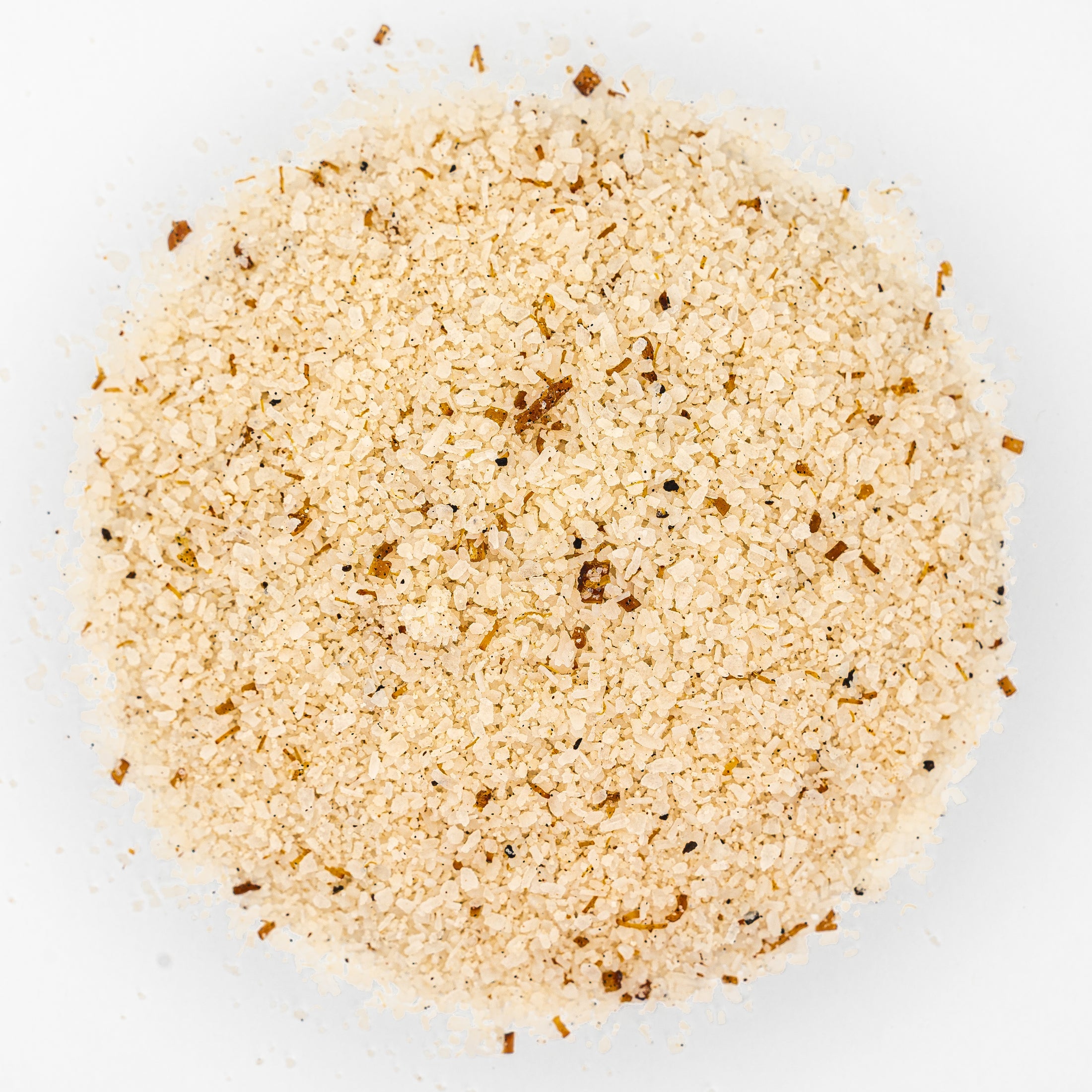 Mound of off white salt with brown flecks. 