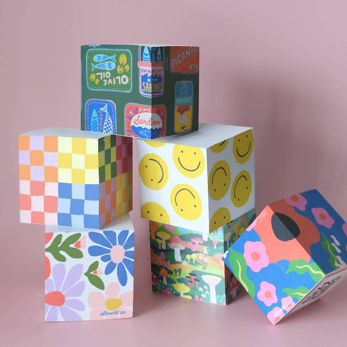 Colorful patterned boxes stacked on a pink background