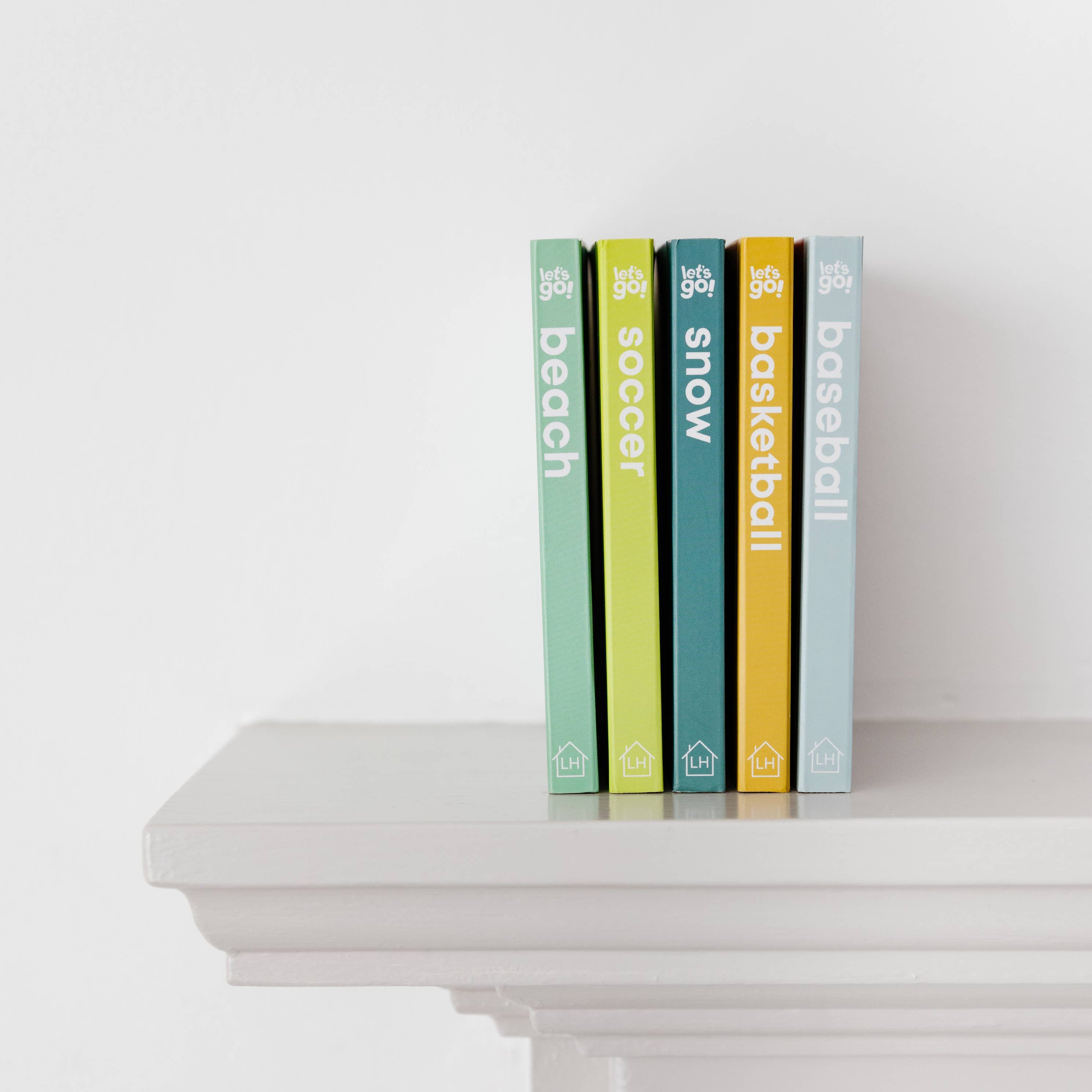 Five books with visible titles on a white surface