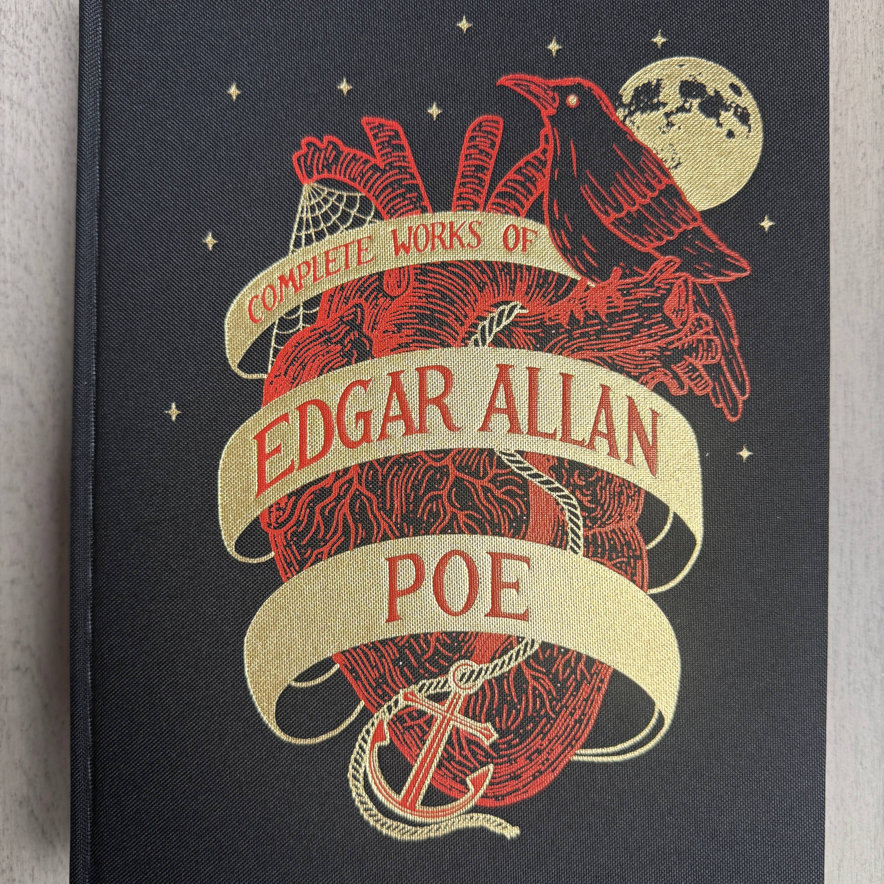 Book cover of 'Complete Works of Edgar Allan Poe' with decorative elements on a gray background