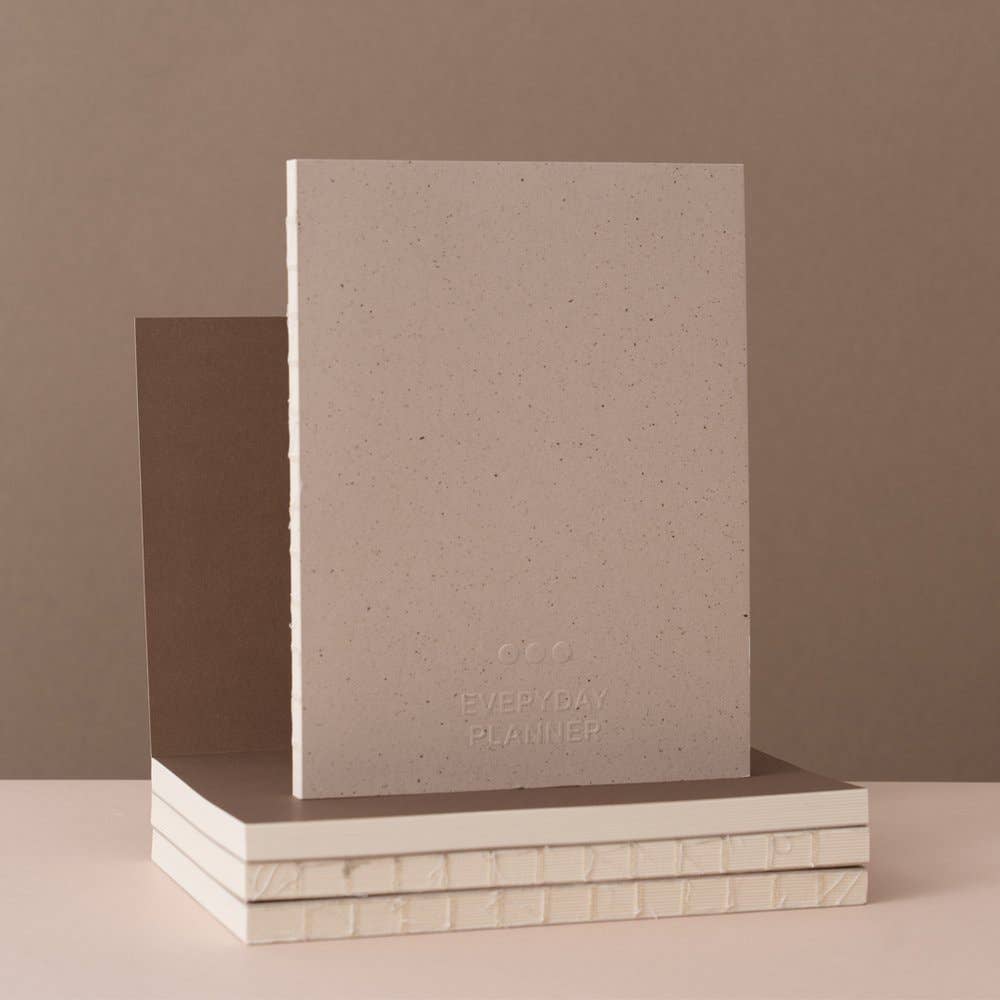 Beige planner with 'Everyday Planner' text on a brown background