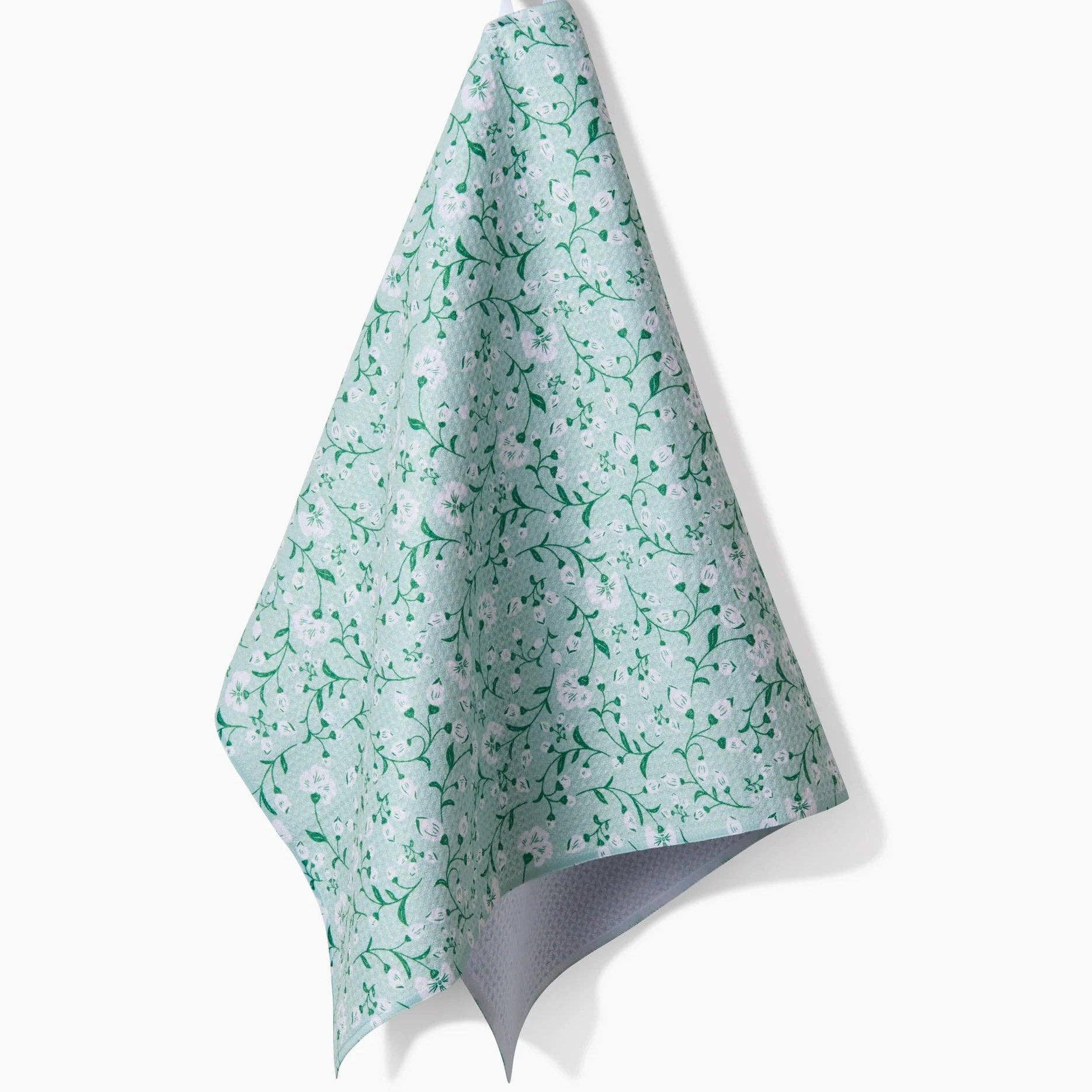 Teal floral patterned towel hanging on a black hook against a white background Tea Towel