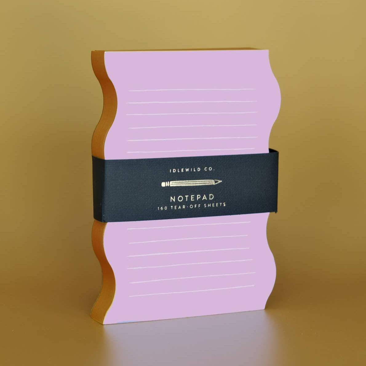 Pink notepad with a black band on a beige background