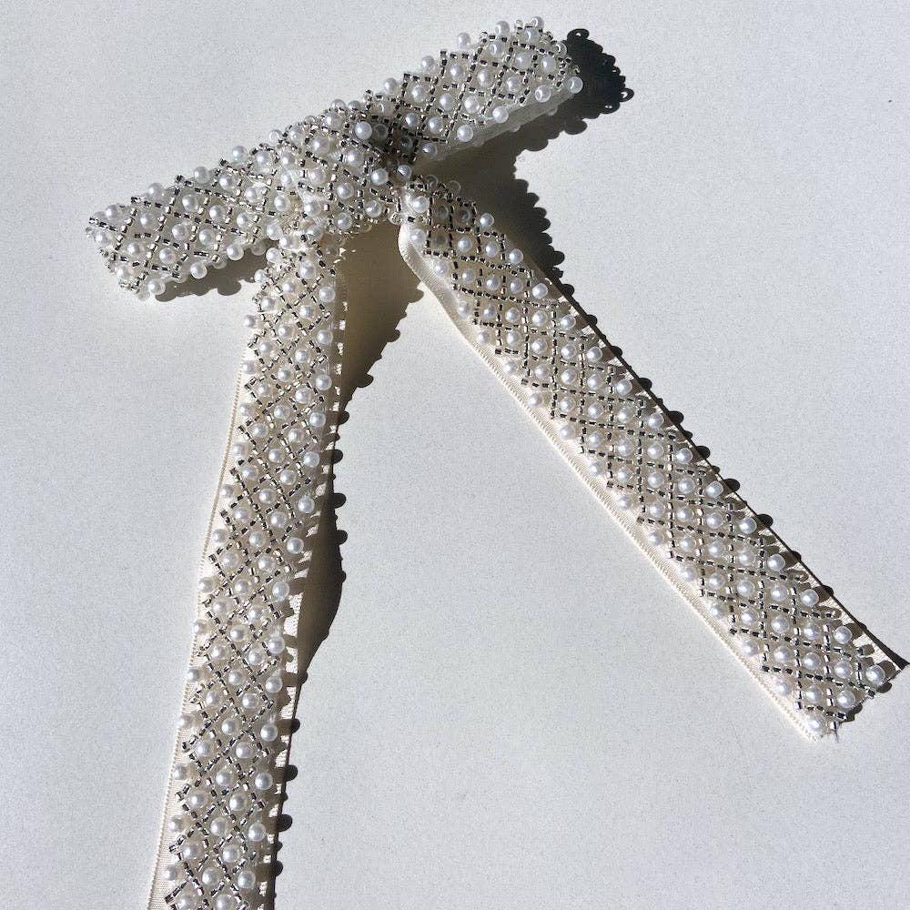 Each hair clip is sewn by hand with meticulously embroidered vegan pearls and metallic beads. It features a versatile French barrette closure, for effortless styling.