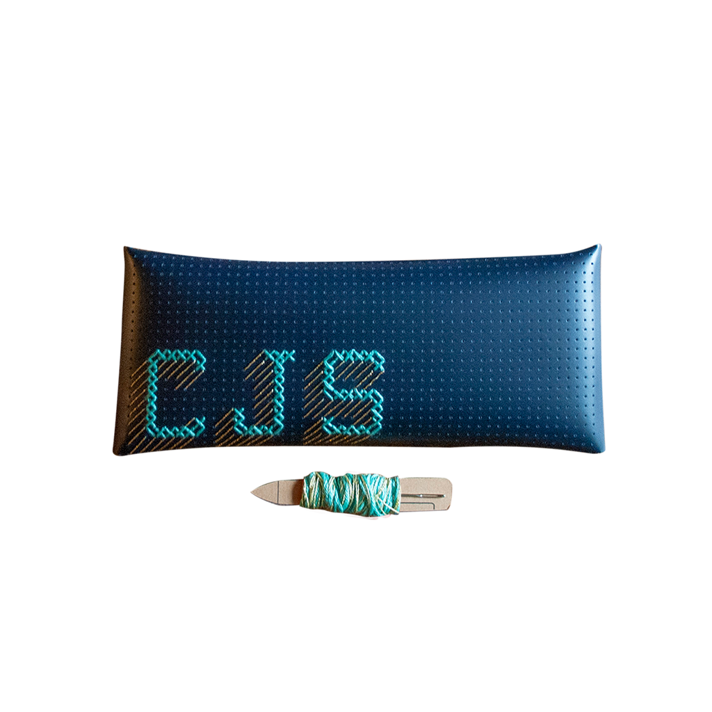 Stitch your own way - this envelope pocket is ideal as a pencil or glasses case and allows you to sew any unique design. Whether you stitch initials, a slogan or the sunglasses template included, it opens out fully for easy stitching. It also opens 2 ways, so it can open from the side or from the top - just pop the metal buttons to fold up whichever way you prefer. The Navy pouch comes with teal & gold thread &amp; needle wrapped on our pen thread-board. It includes our 3D alphabet template to add initials
