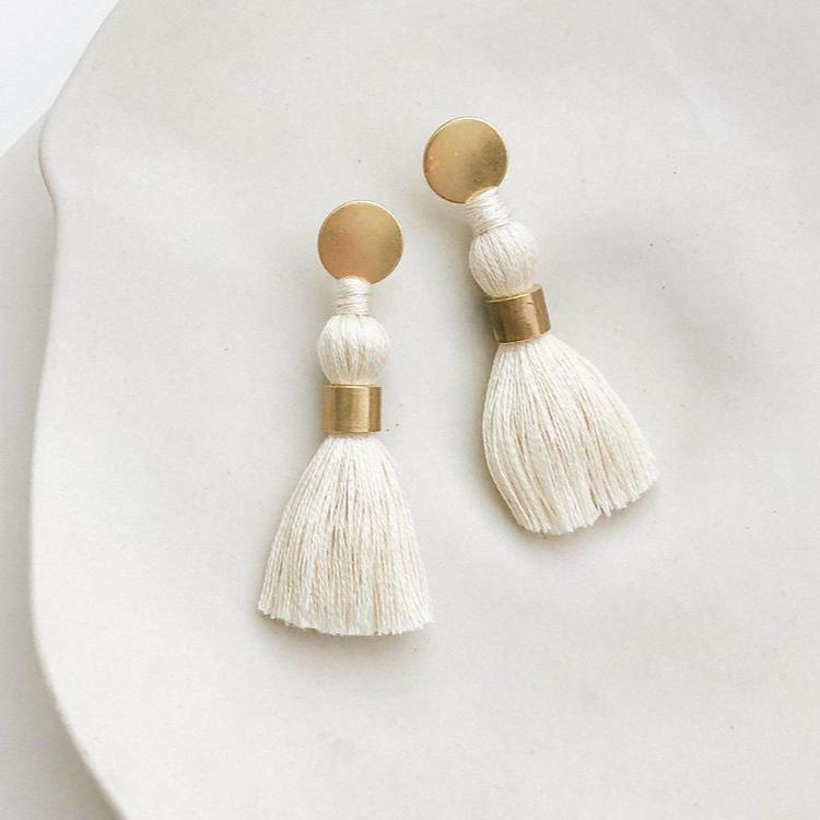 The elegant tassel hangs from a brass stud disc. A minimal version of the multiple tiered tassel earrings
