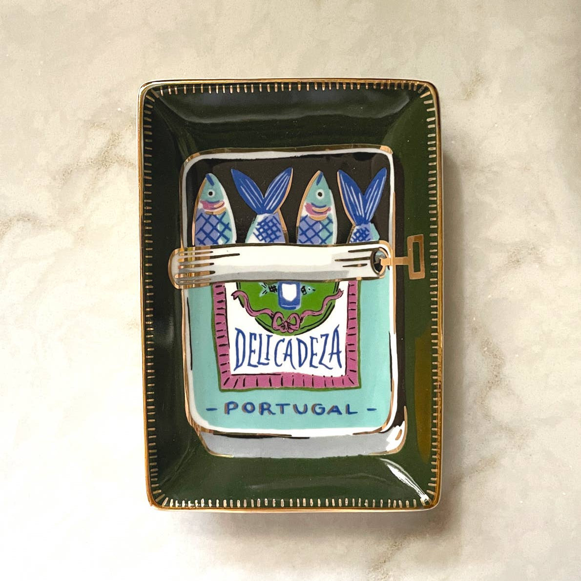 A fan favorite giftable–Our ceramic trinket dishes are the perfect catchall for your nightstand or dresser. White ceramic is adorned with our colorful, hand-painted designs, and we lined the edge in 10k gold for added flair. Perfectly packaged in plastic-free gift boxes, pretty enough to give without wrapping!

• 3″ x 3″ Dish

• Ceramic with 10k Gold Detailing

• Plastic-Free Gift Box