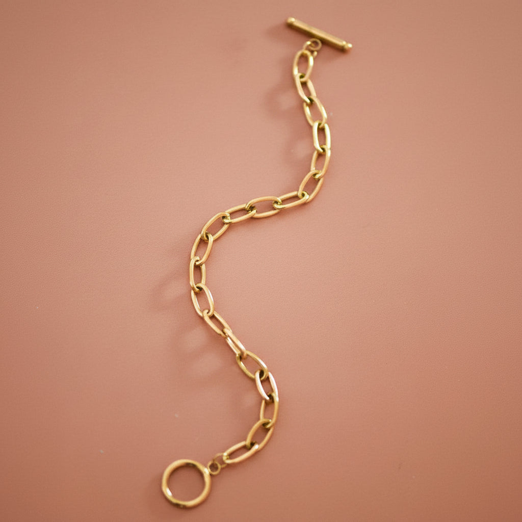 18K Gold Plated Stainless Steel Paperclip Chain Bracelet with Toggle Clasp. This bracelet features elongated paperclip-style links with a clean, modern silhouette and a classic toggle closure. This item is hypoallergenic, waterproof and tarnish-resistant. To prolong the shine and finish of the gold plating, contact with chemicals such as lotions, perfumes, and cleaning products should be avoided.