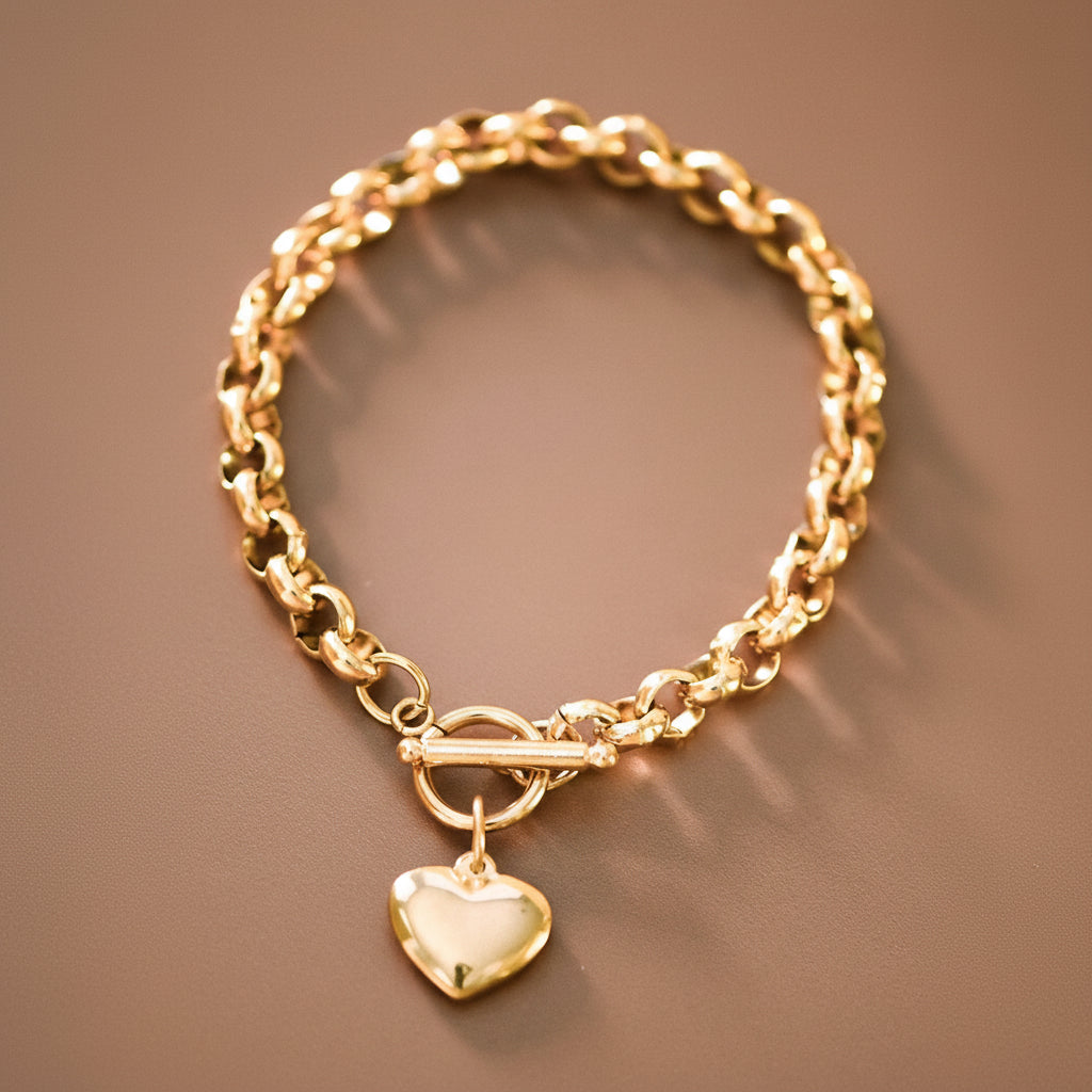 Elevate your jewelry collection with this stunning 18K gold plated stainless steel bracelet, featuring a hanging heart charm and a secure toggle clasp. Hypoallergenic and waterproof, it's perfect for everyday wear without worry. The tarnish-resistant finish maintains its lustrous shine, though avoiding contact with lotions, perfumes, and cleaning products will help preserve its beauty. A versatile piece that transitions seamlessly from casual to elegant occasions.
