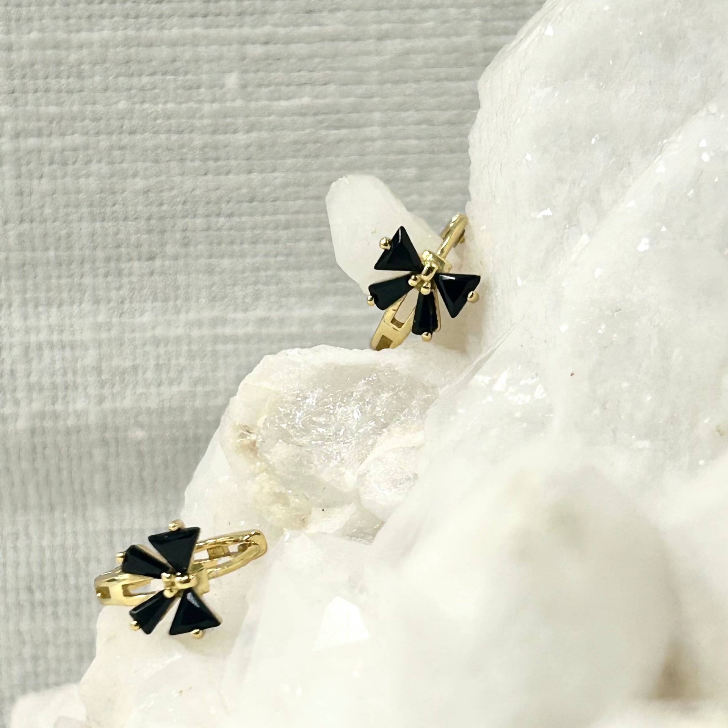 Add a touch of fun and classy to your every day by sporting these little bow huggie hoops! Bows aren't just functional and pretty knots for sealing gifts, they can represent strength, union, and beauty.

•&nbsp;925 sterling silver with gold plating

• Extra layer of tarnish resistance

• Black Cubic Zirconia stones

• Manufactured for our curated collection.